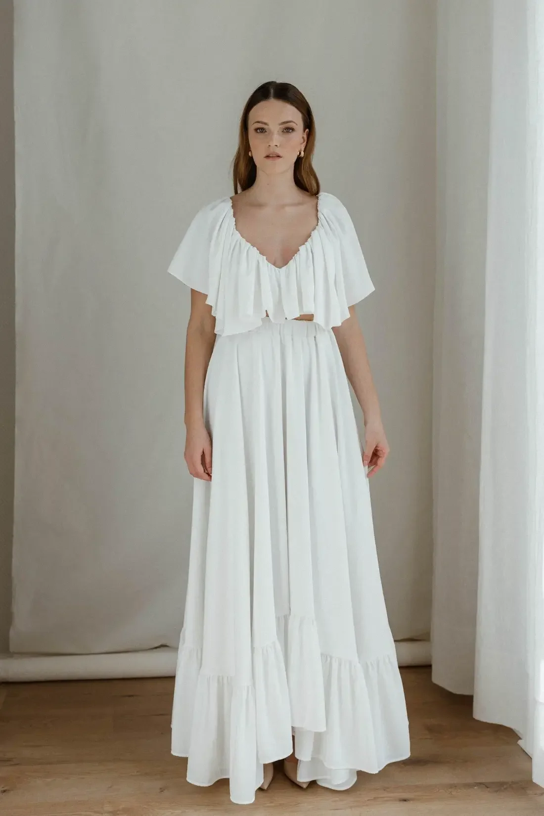 Kaksiosainen Louisa-hääpuku, jossa on leveä kellohelma ja takaa rusetille solmittava yläosa. Leikkisä ja ilmava kokonaisuus on valmistettu kierrätysmateriaaleista