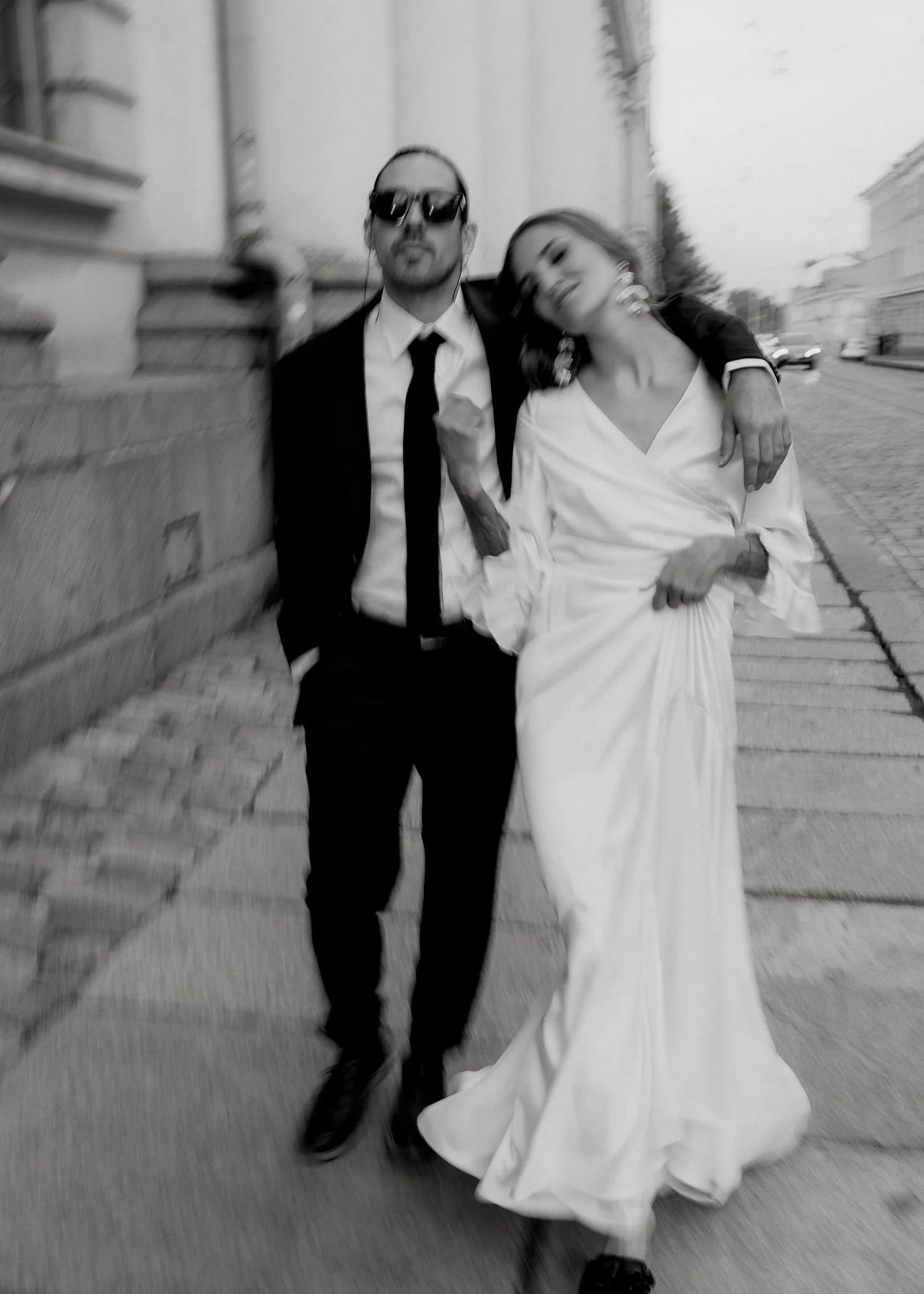 Hääpari kävelee kadulla nojaten toisiinsa.