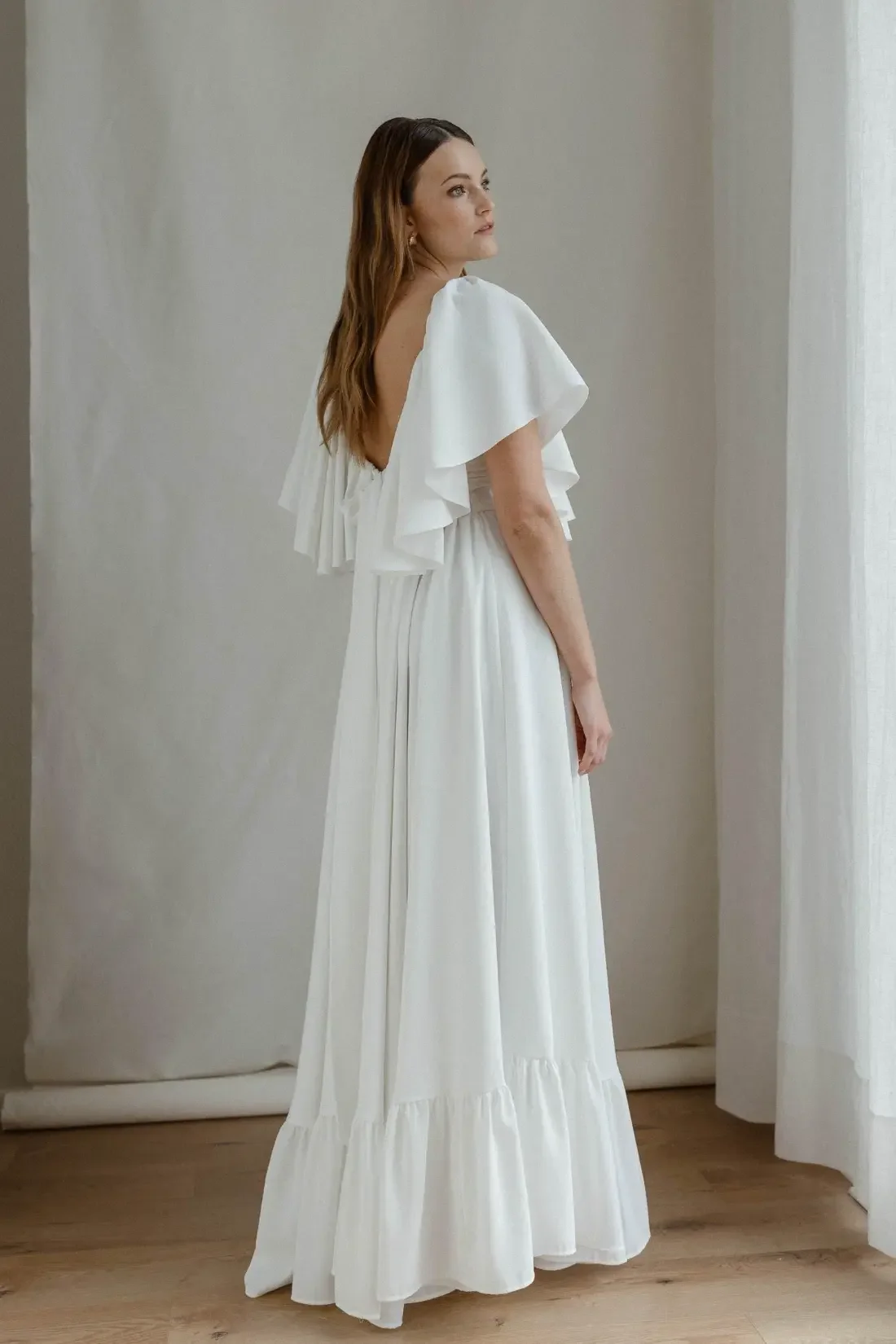 Valkoinen Louisa-hääasu, joka sopii mallinsa ansiosta loistavasti myös raskaana olevalle. Kuvassa näkyy puvun leveä helma ja säädettävä solmukiinnitys takana.