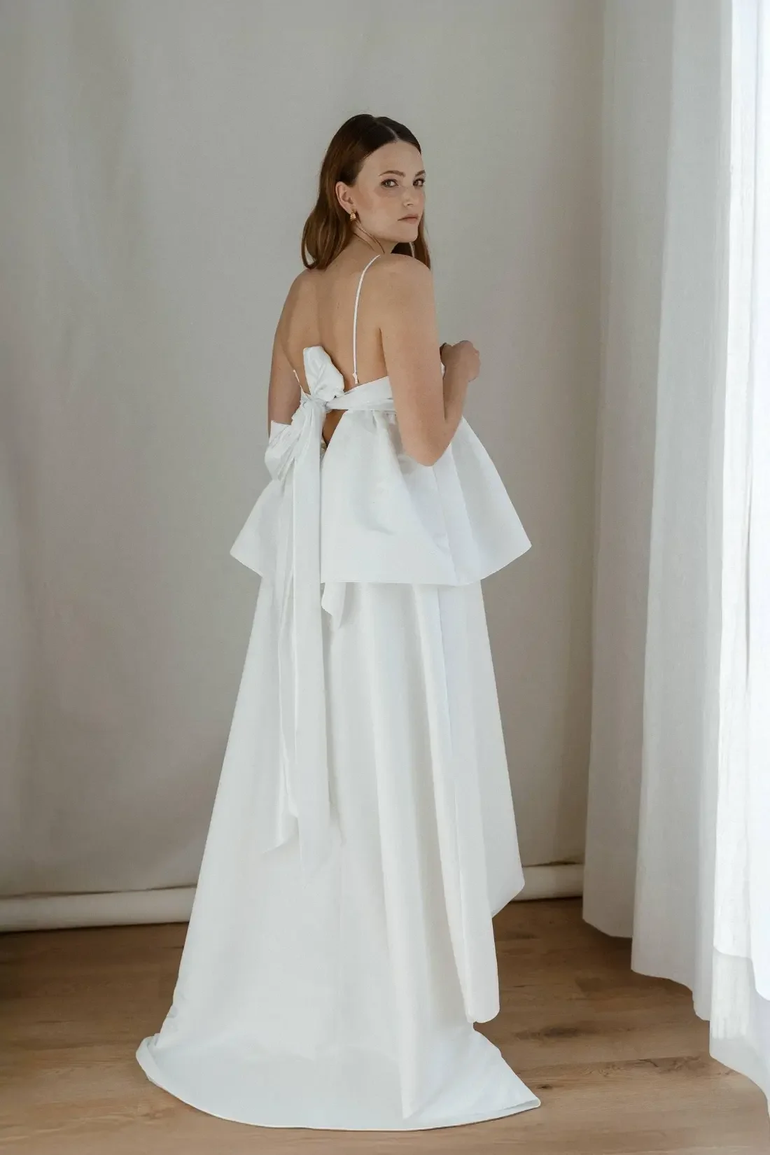 Minimalistinen Jane-satiinihääpuku, jossa on kaunis kiilto ja mukautuva siluetti. Valmistettu Helsingissä kierrätetyistä materiaaleista.