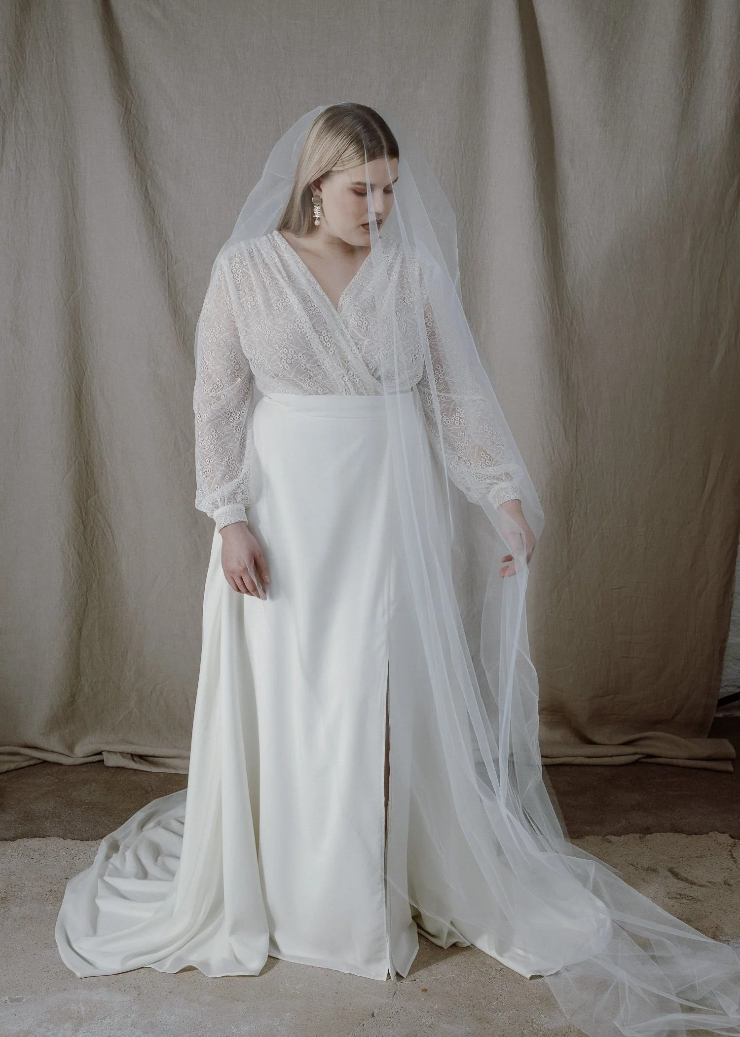 Valkoinen Avallon-hääasu, jossa on kukkakuvioinen pitsitoppi ja vyötärölle solmittava satiinivyö. Moderni ja mukava hääpuku joustavasta materiaalista.