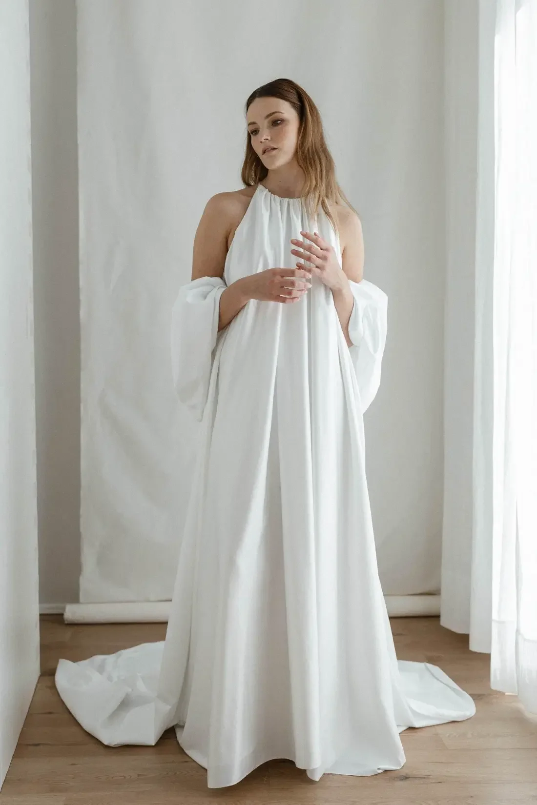 Kevyt ja ilmava Edith-hääpuku, jossa on näyttävä erillinen laahus. Puku on valmistettu kierrätysmateriaaleista ja siinä on minimalistinen, tyylikäs siluetti