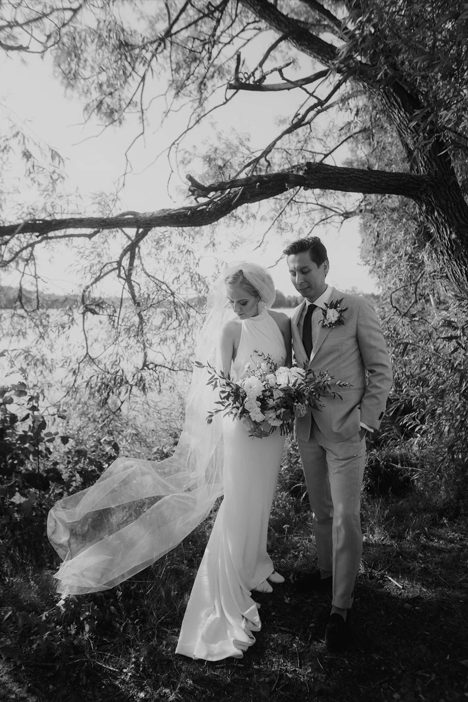 Hääpari seisoo puun alla.