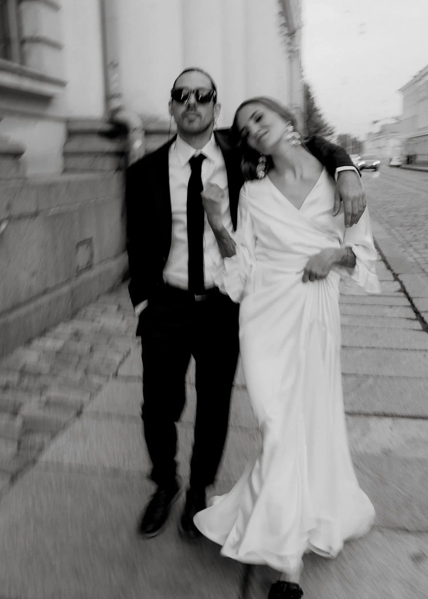 sulhanen ja morsian pitkässä häämekossa kävelevät kadulla