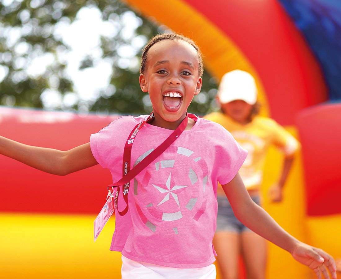 Female Student Smiling at Camp Dragon on an inflable bouncey castle.jpg