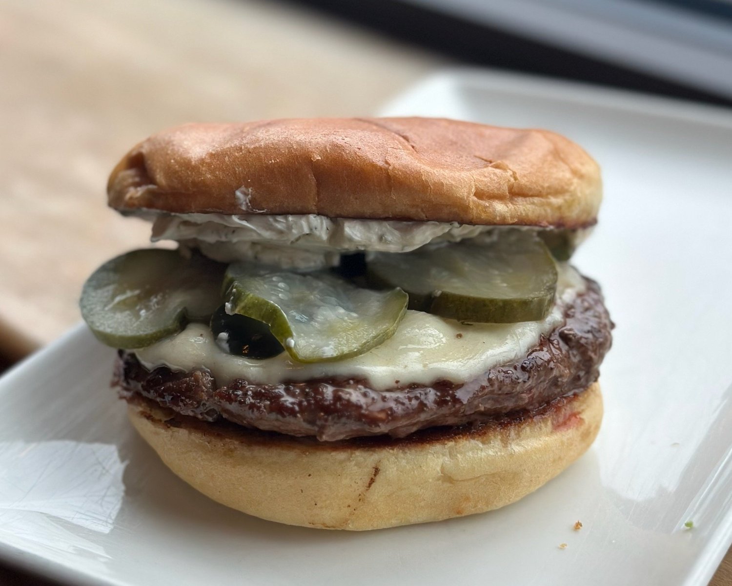 Blue Roof Bistro - Roasted Chili Steak Burger has a roasted chili sauce,flank  steak, beef patty, arugula, and melted Swiss in a potato bun served w/ a  side is the special of