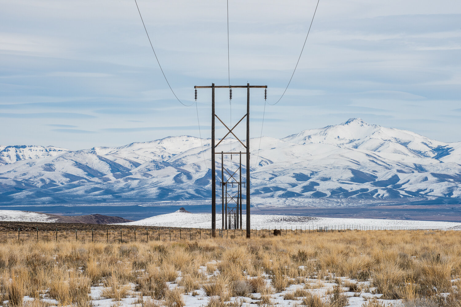 An existing transmission line passes through the heart of Thacker Pass, following the slope down into the Quinn River Valley below. The Santa Rosa Mountains rise up in the background.Russel Albert Daniels / High Country News