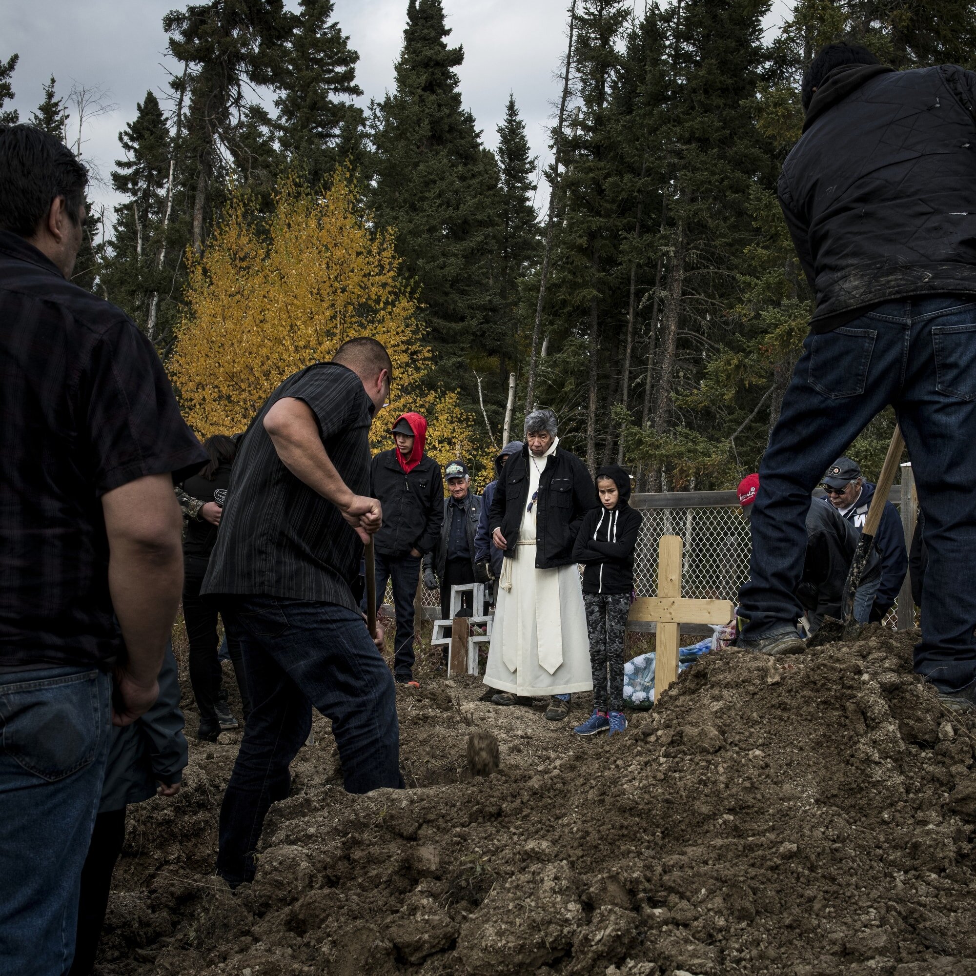 Father Kennith Kitchekeesik administers a funeral in Split Lake. The banks of the cemetery have been reinforced by riprap to prevent erosion after human remains were found exposed. “Skull and bones are starting to pop out here and there along the ba…