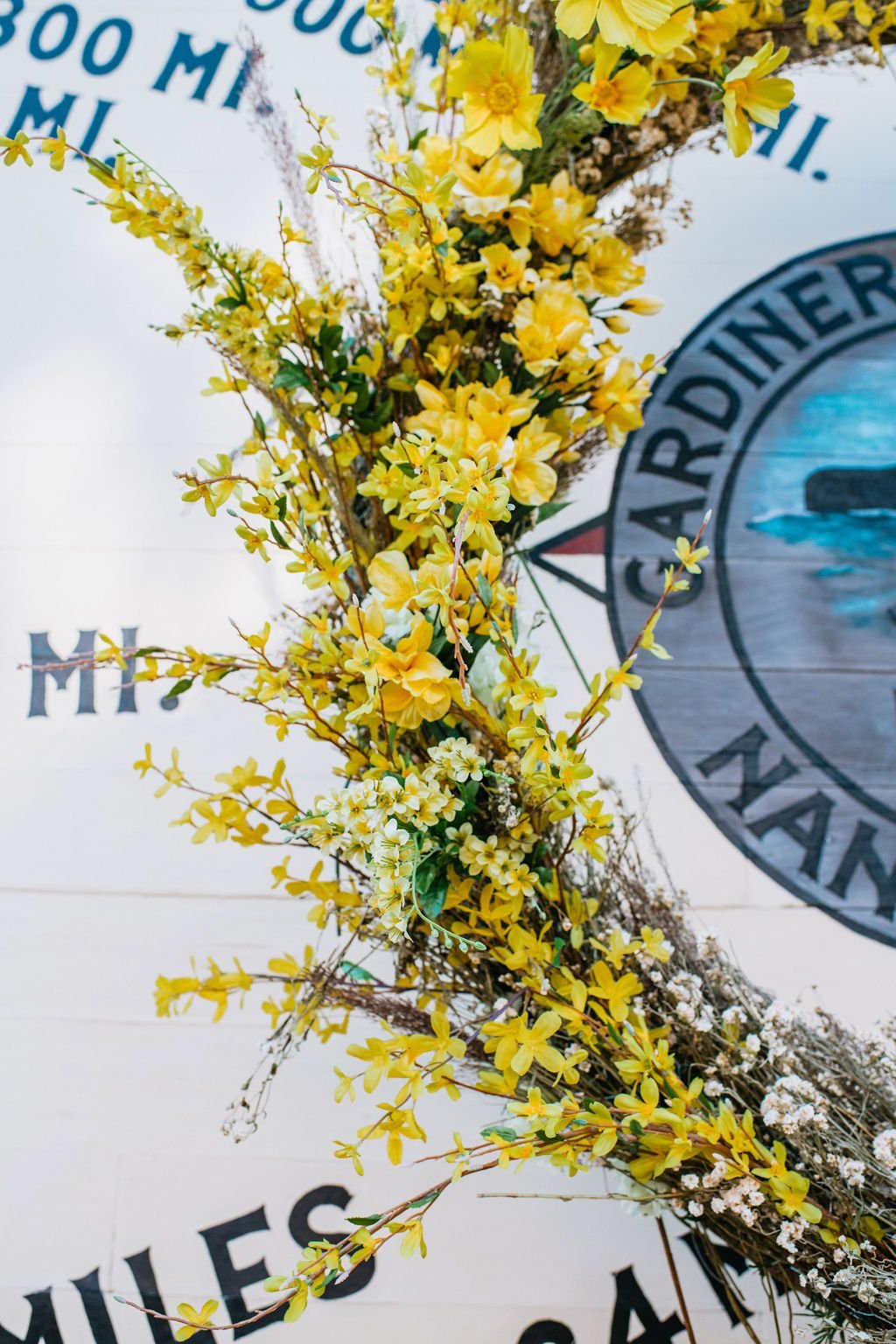 Yellow flowers arranged on a white surface with the Marine Corps emblem in the background.