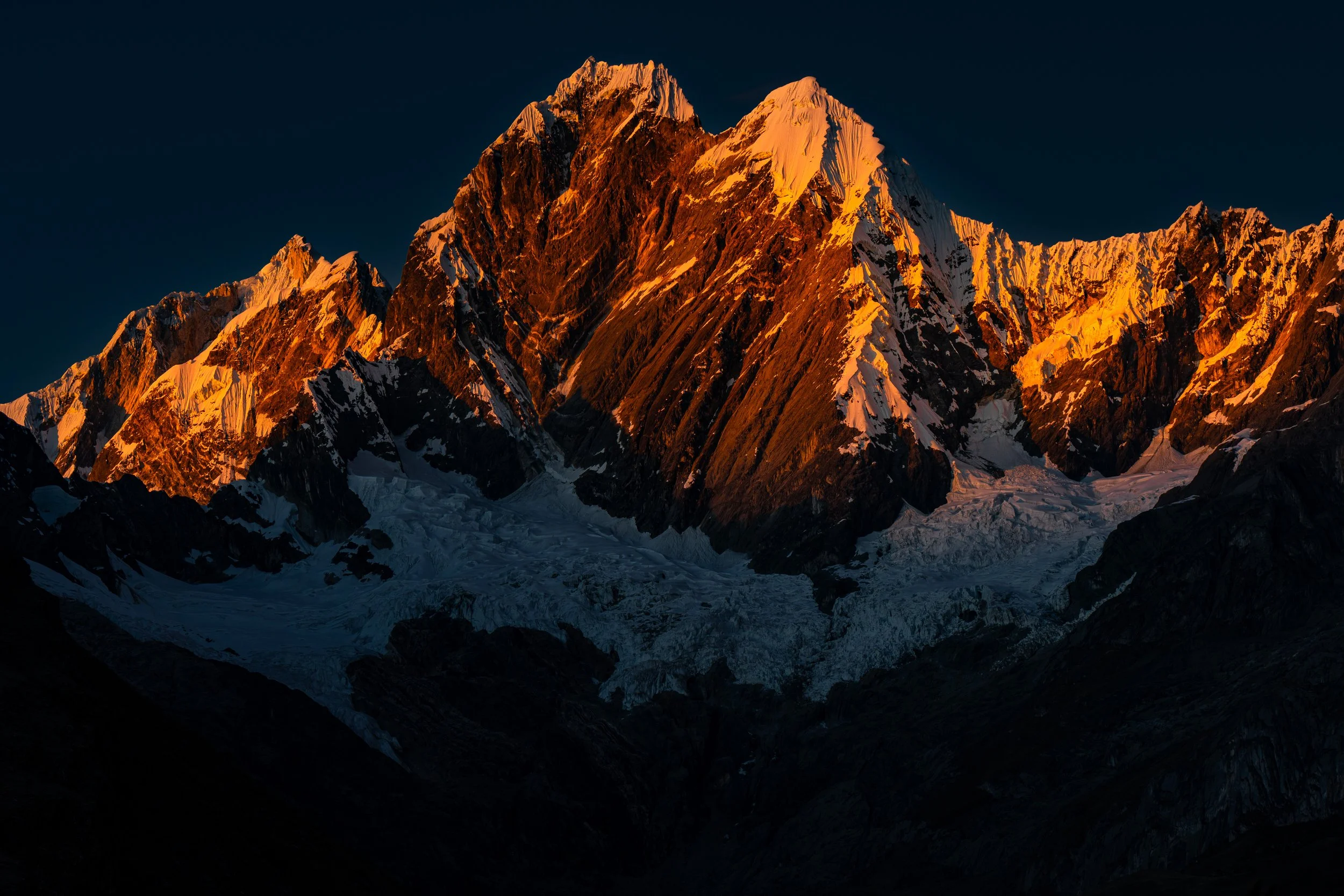 Yerupaja Grande (6,617 m, left) and Yerupaja Chico (6,089 m, right) glow in the morning sun. This telephoto view is from campamento Janca.