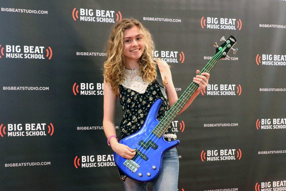 happy big beat music studio student with bass guitar lessons