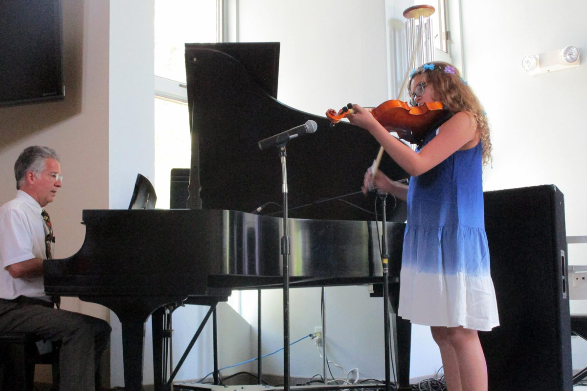 Violin student performing with piano teacher