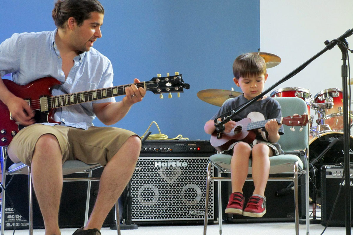 young guitar music student performing at annual showcase