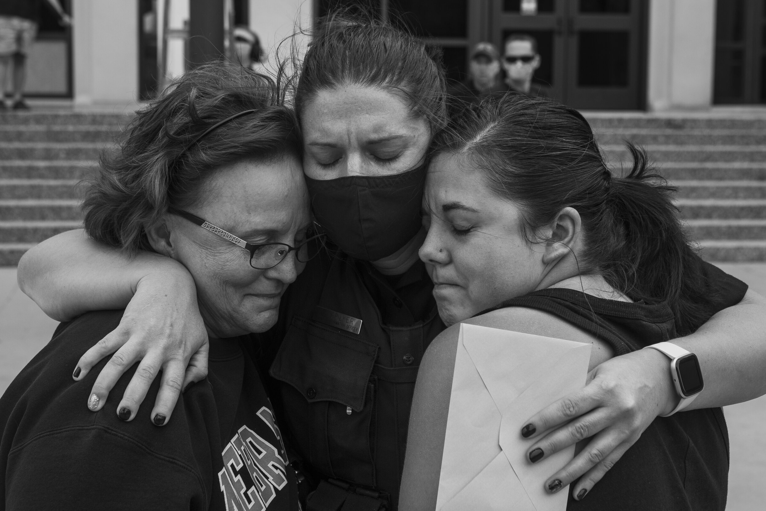  PIO officer Erin Spilker (center) is hugged by two people who did not offer their names during a funeral procession for fallen officer Mario Herrera  on Monday, September 7, 2020, in Lincoln, Nebraska. Herrera passed away in the early hours of Septe