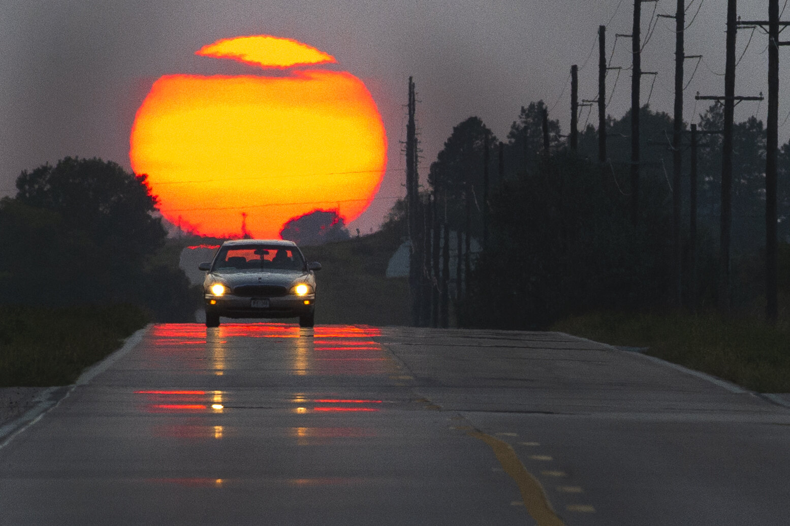  A driver makes their way east as the sun, obscured by smoke from wildfires in the west, sets behind them Monday, September 21, 2020, in Denton, Nebraska. KENNETH FERRIERA, Journal Star. 