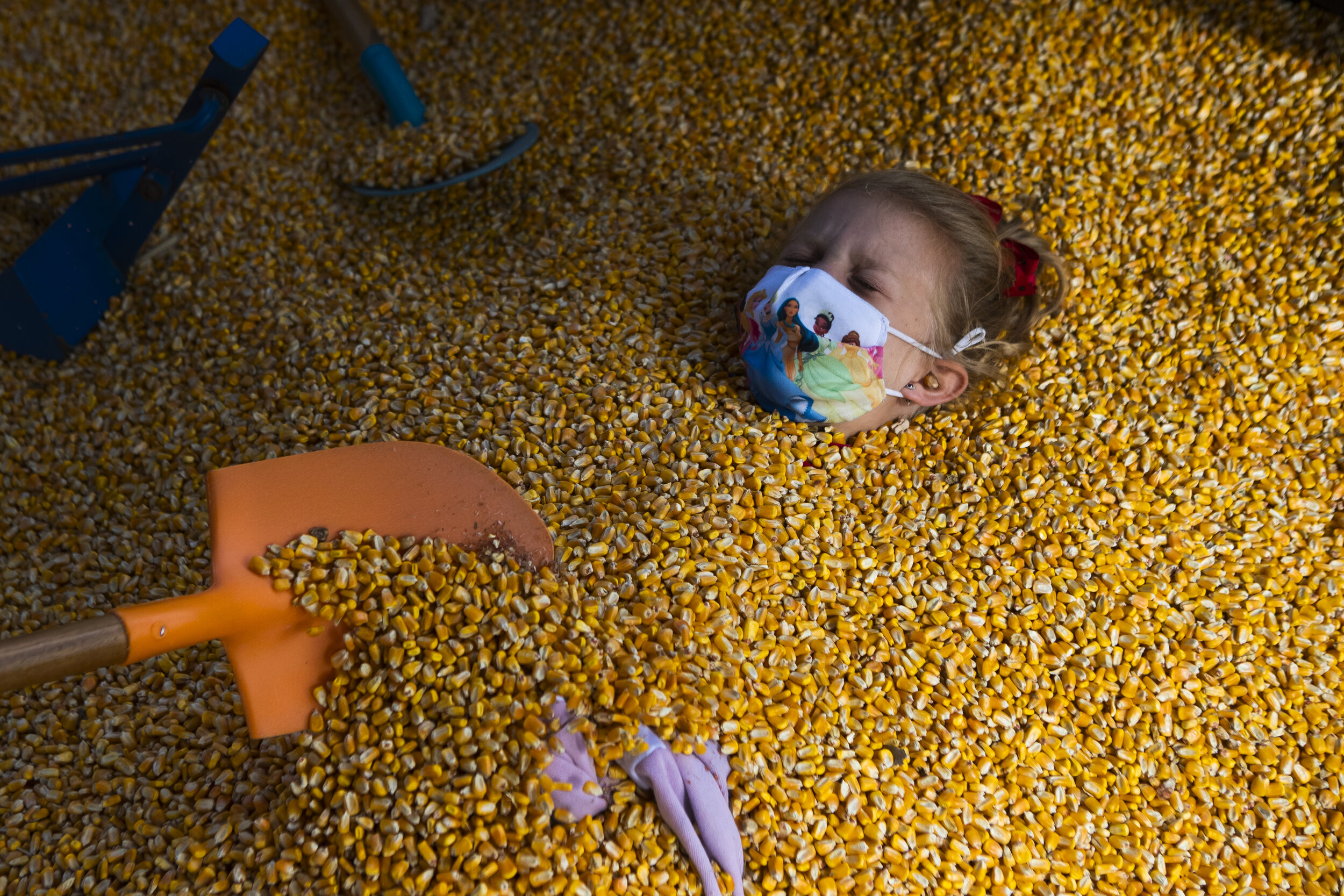  Mickenna Korbel is buried up to her neck in corn kernels by her mother Mindy Korbel, and Kyler Korbel at the Roca Berry Farm on Monday, September 28, 2020, in Roca, Nebraska. Roca Berry Farm opened for the Fall 2020 season on September 19, 2020. KEN