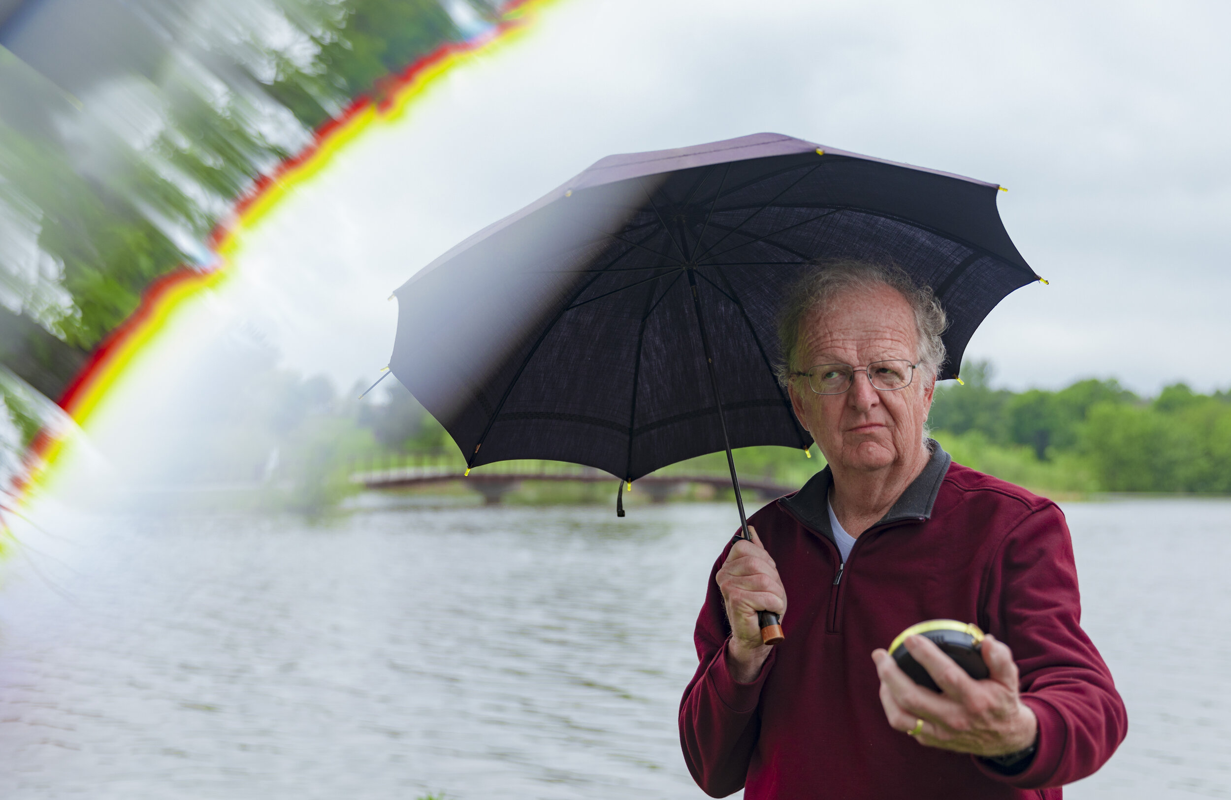  Ken Dewey one of the all-time popular professors at UNL for his love of weather poses for a portrait on Friday, May 22, 2020, at Holmes Lake Park. The rainbow seen is achieved using a triangular prism. Ken spends most of his retirement still studyin