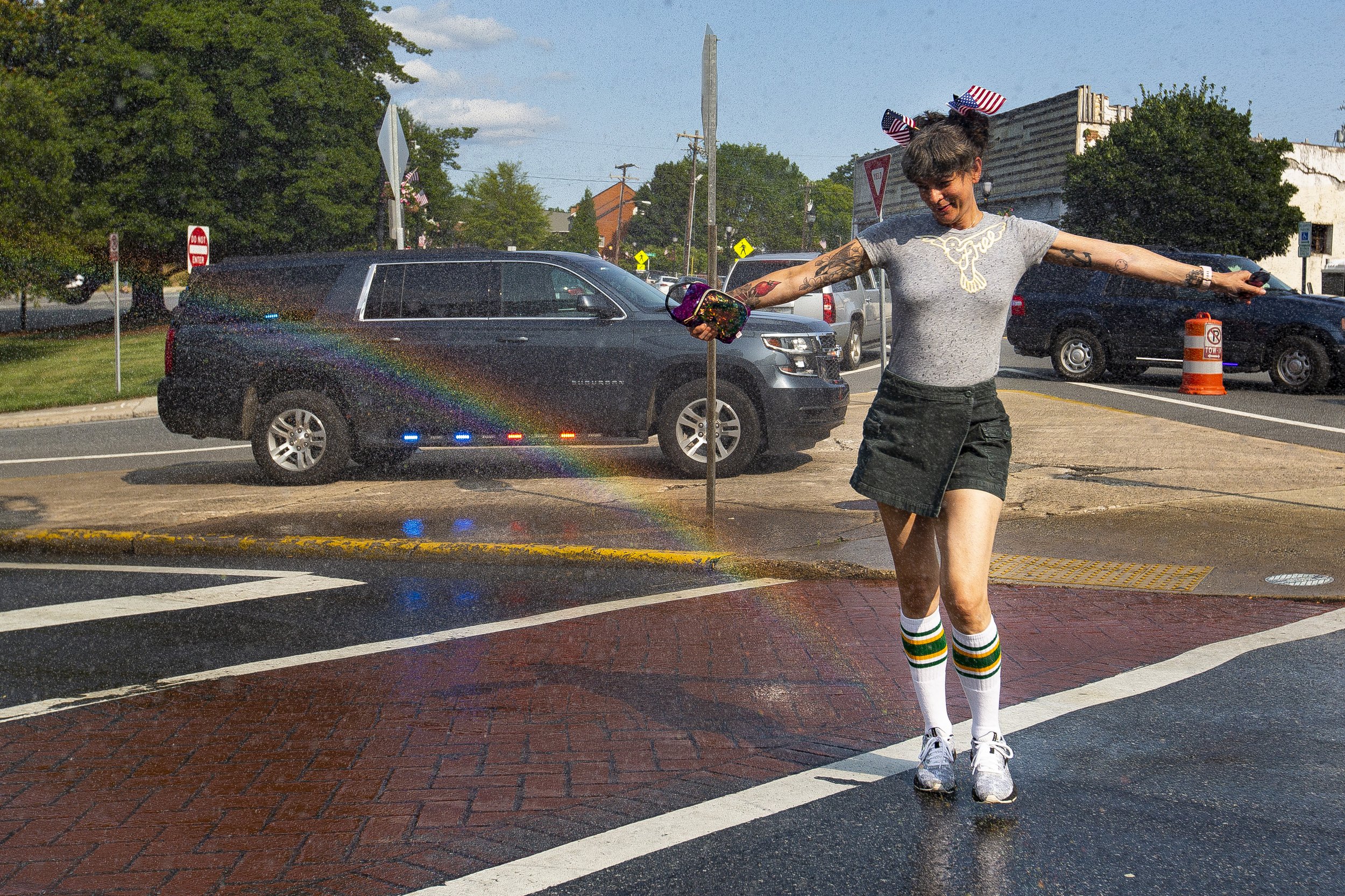  Sara Cox dances through a rainbow refracted by water sprayed by the Greensboro Fire department during the Fun Fourth in Downtown Greensboro, N.C., on Saturday, July 3, 2021.   The Fun Fourth festival is took place along Elm Street, from February One