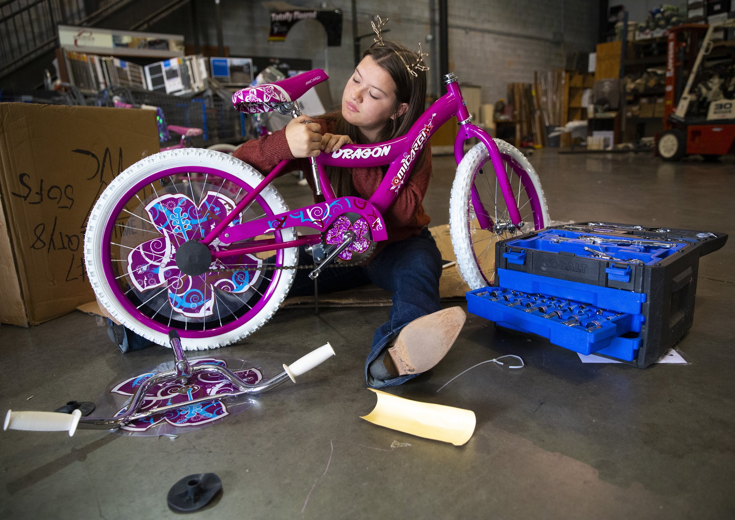  Michaela Isaacson assembles a bicycle donated to Toys for Tots inside of a warehouse lended by Totally Floored which is used for toy storage, in Greensboro, N.C., on Thursday,  December 2, 2021.    