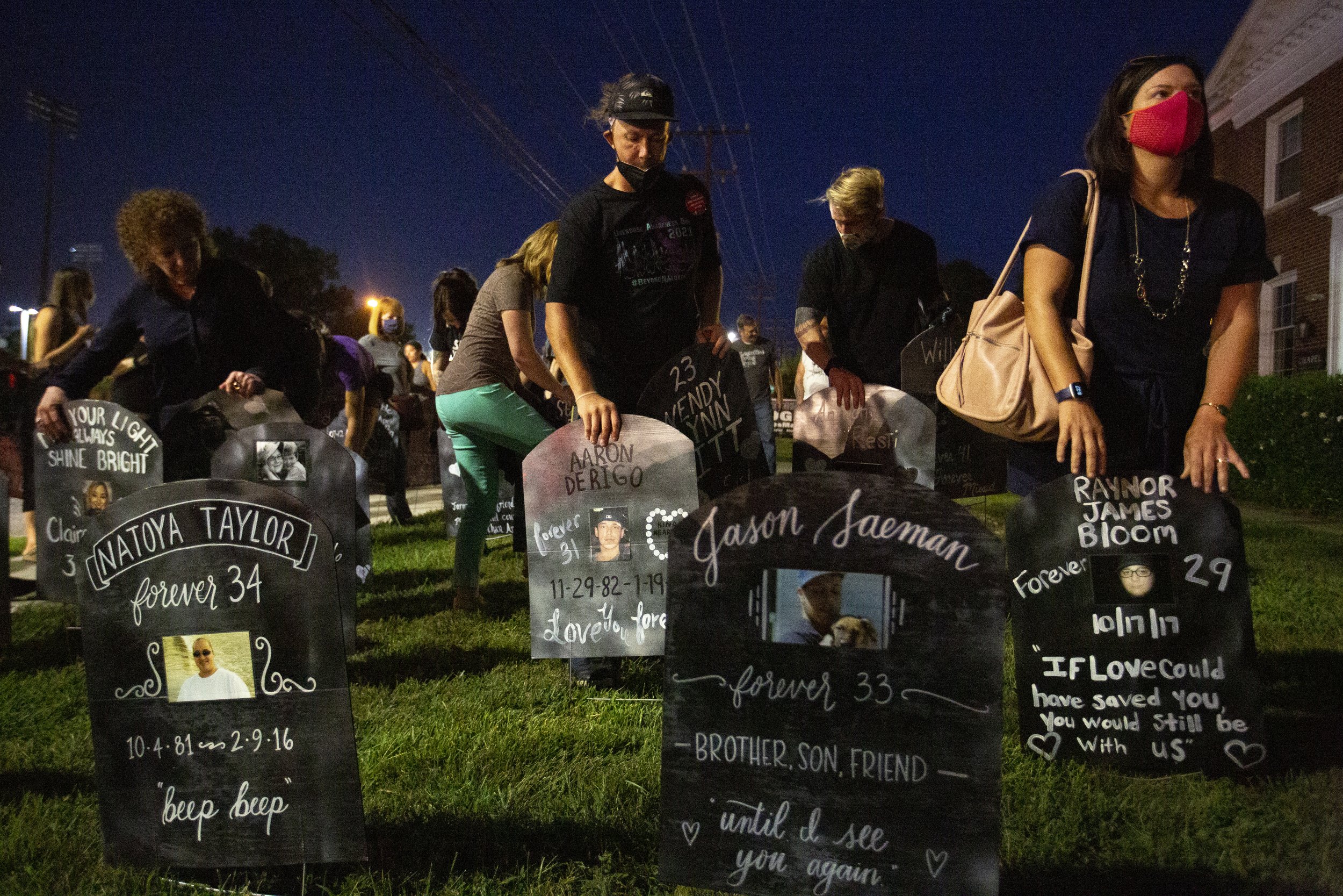  In an act of remembrance attendees of the Overdose awareness ceremony place makeshift tombstones of those lost to overdose in the grassy area out in front of the College Park Baptist Church in Greensboro, N.C., on Monday, August 30, 2021.  