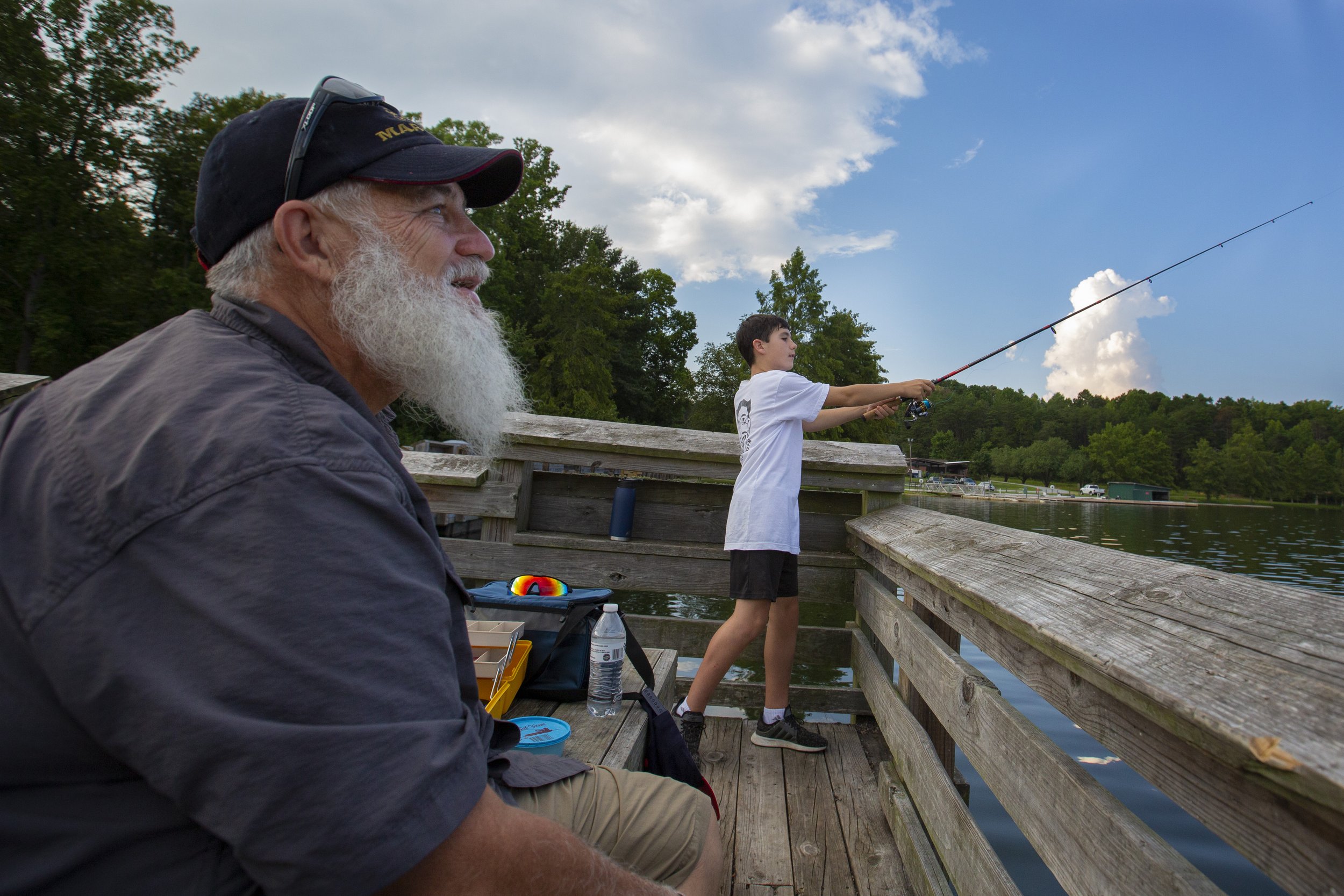  Chrystian Cross casts his rod while fishing with his grandfather, Dan Cross, before sunset at Lake Higgins in Greensboro, N.C., on Wednesday, August 25, 2021.  