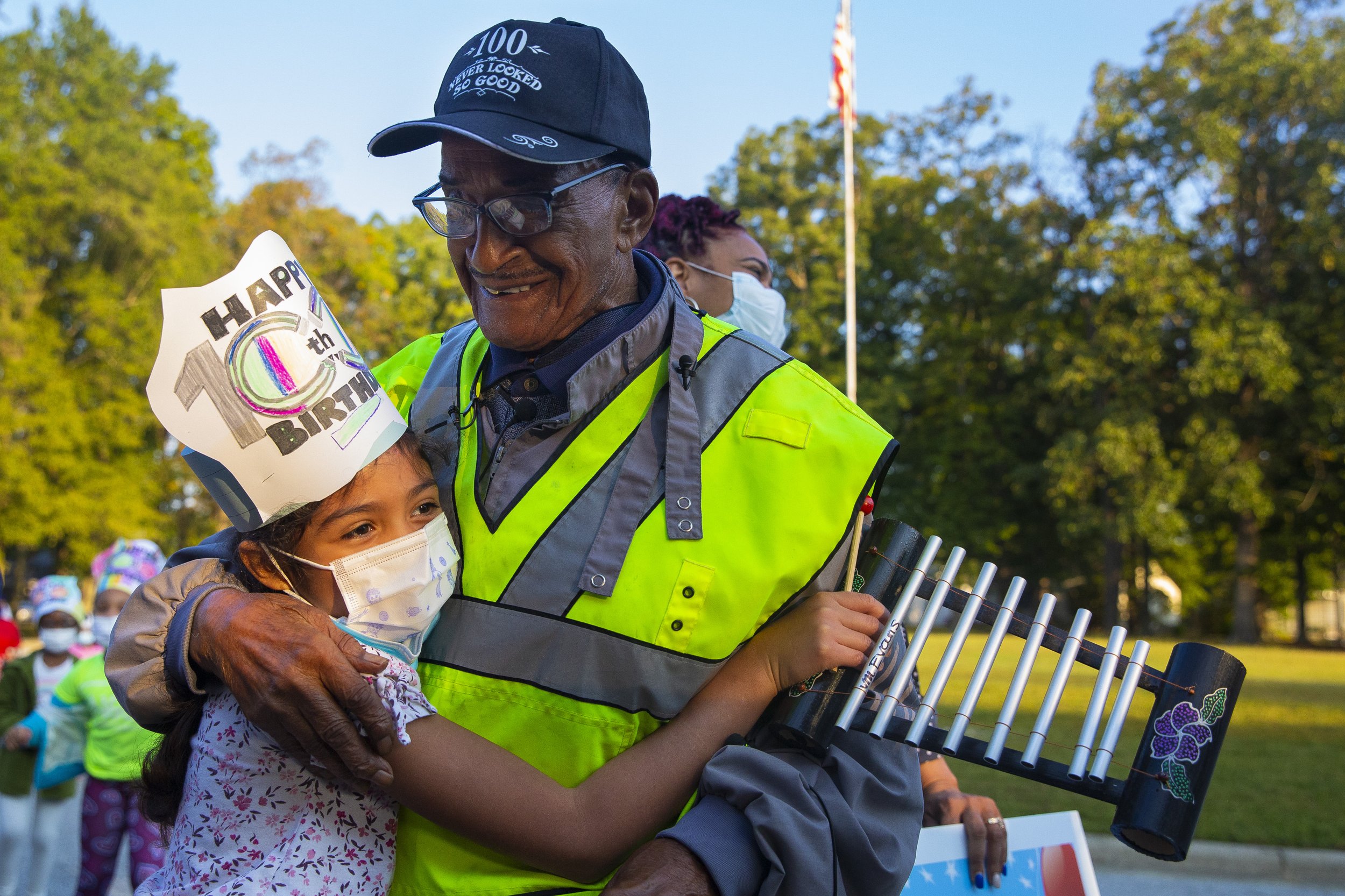  A Peck Elementary School student hugs Thomas Faucette, a crossing guard for Peck Elementary School, during a birthday celebration in honor of his 100th birthday at Peck Elementary School in Greensboro, N.C., on Wednesday, September 29, 2021.     
