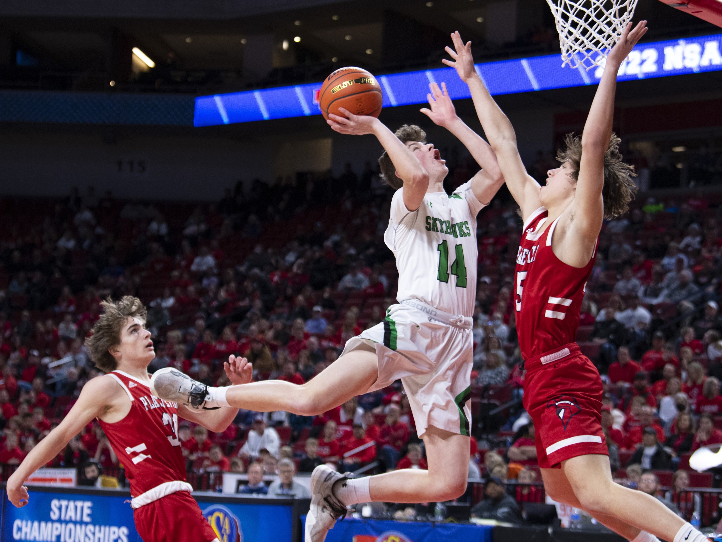  Omaha Skutt's Benjamin Teal (center) goes up for a shot against Platteview's Anthony Lewis (right) in the fourth quarter during a Class B boys semifinal game at Pinnacle Bank Arena on March 9, 2022, in Lincoln, Nebraska. 