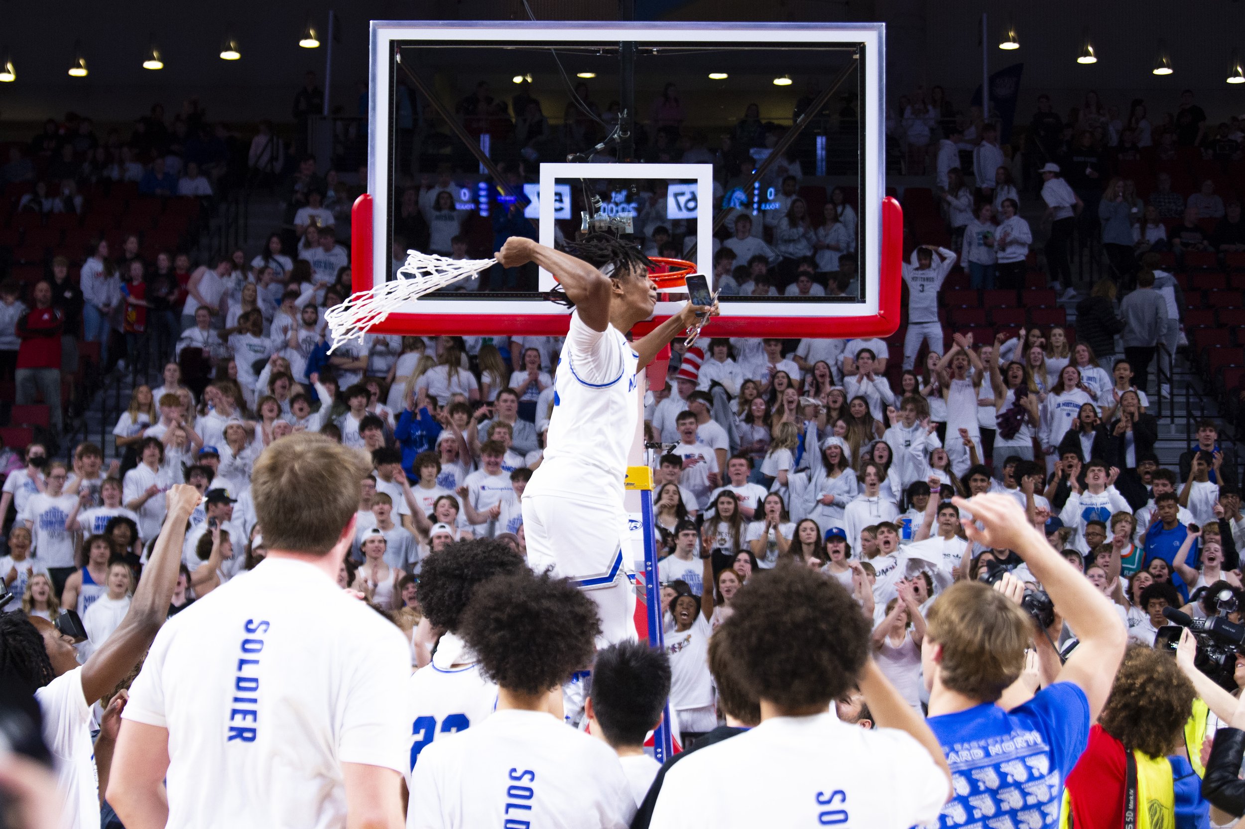  Millard North's David Harmon celebrates after cutting the net done, as his teammates and fans celebrate alongside him, during the Class CA boys championship at Pinnacle Bank Arena on March 12, 2022, in Lincoln, Nebraska.  