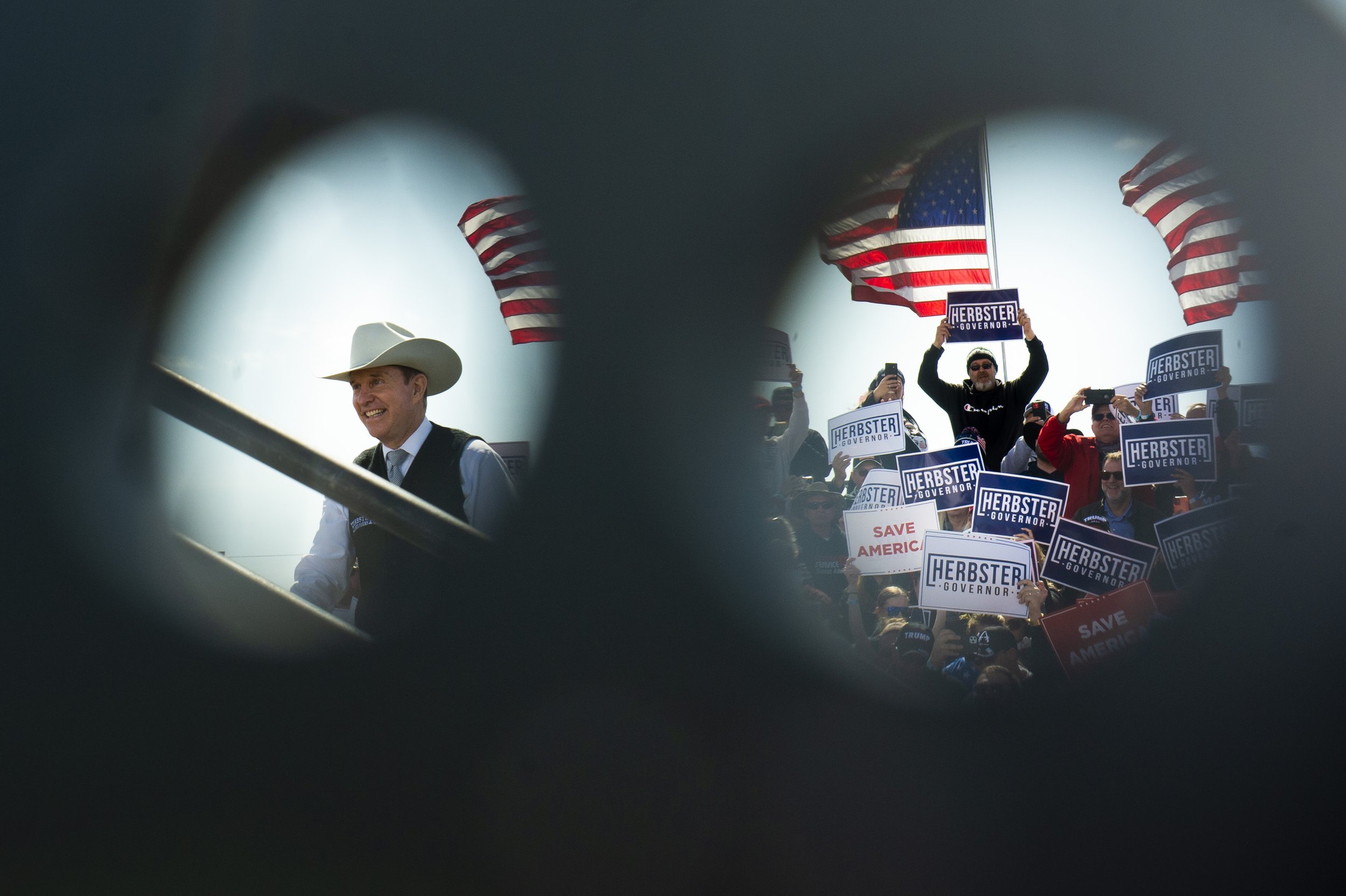  As seen through open cable holders, avid supporters of Gubernatorial candidate Charles Herbster and former president Donald Trump, cheer as Herbster (left) takes the stage during a Trump rally for him at the I-80 Speedway on May 1, 2022, in Greenwoo