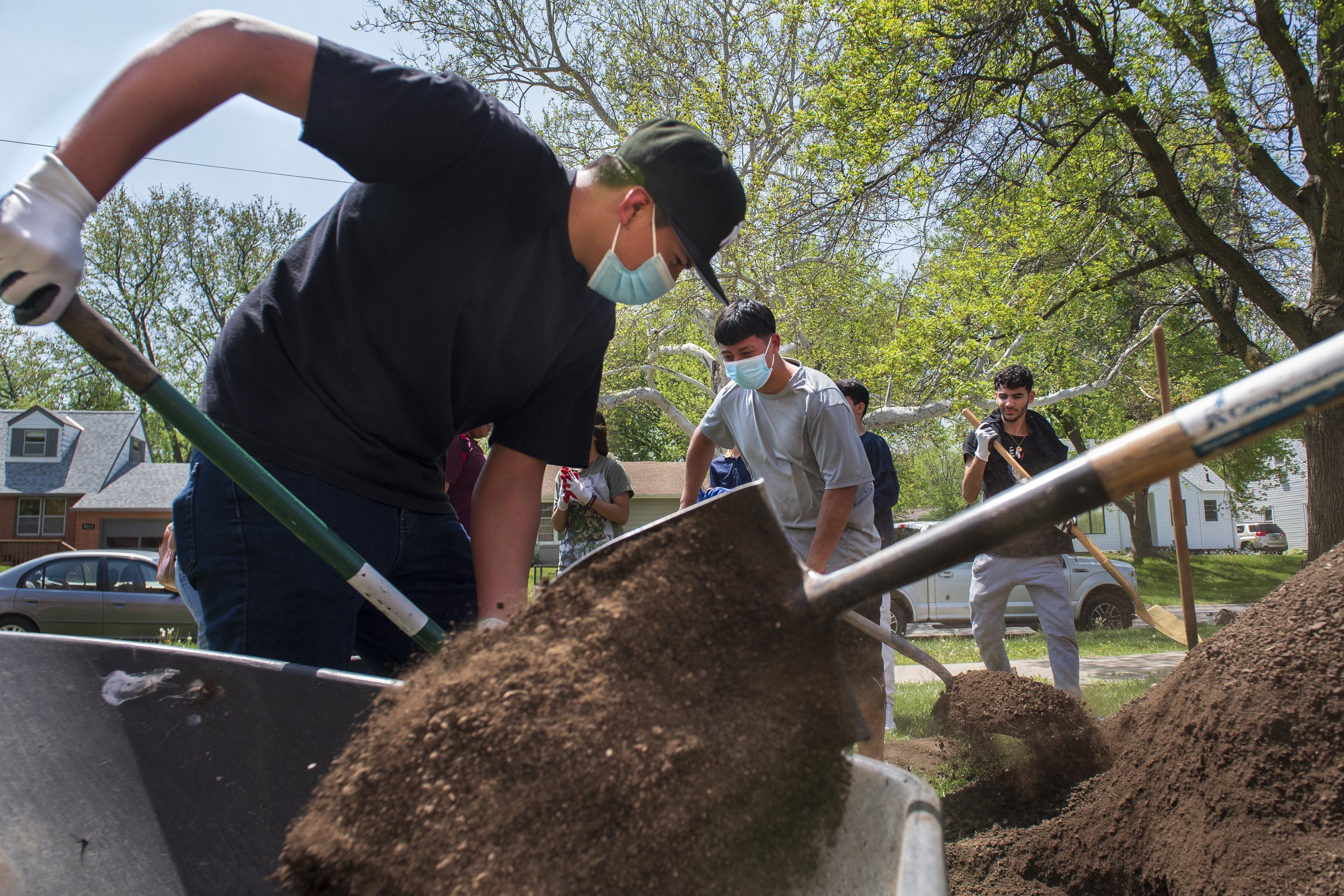  Lincoln Northeast ELL students fill wheelbarrows with dirt to fill garden beds as they build a seedfolks community garden outside of Lincoln Northeast High School on May 11, 2022, in Lincoln, Nebraska. ELL students conceived and organized the garden