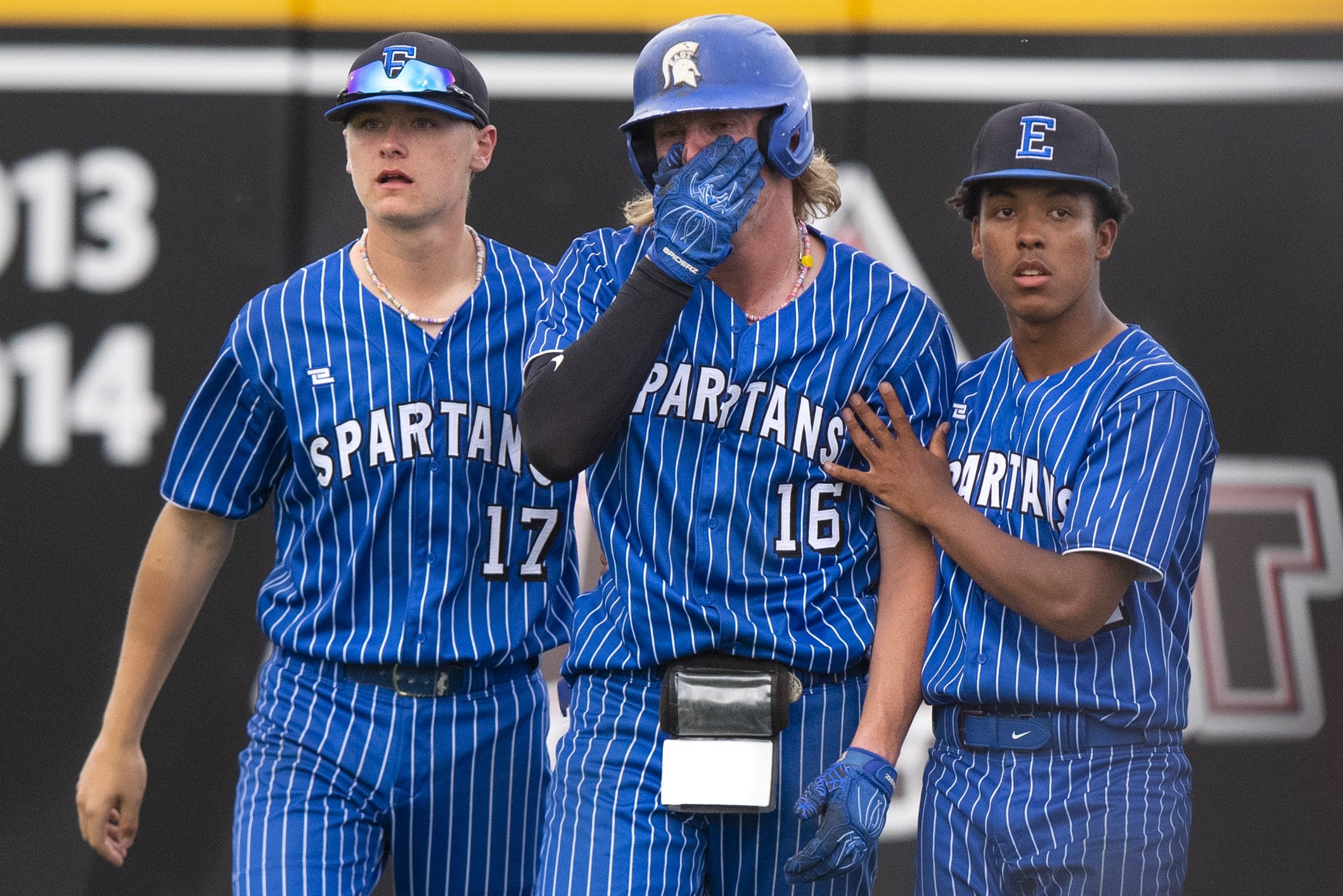  Cooper Erikson (center) is consoled  by his teammates Eli Eriksons (left) and Jaelyn Worthley after losing to Millard West in the Class A semifinal game at Tal Anderson Field on May 19, 2022, in Omaha , Nebraska. 