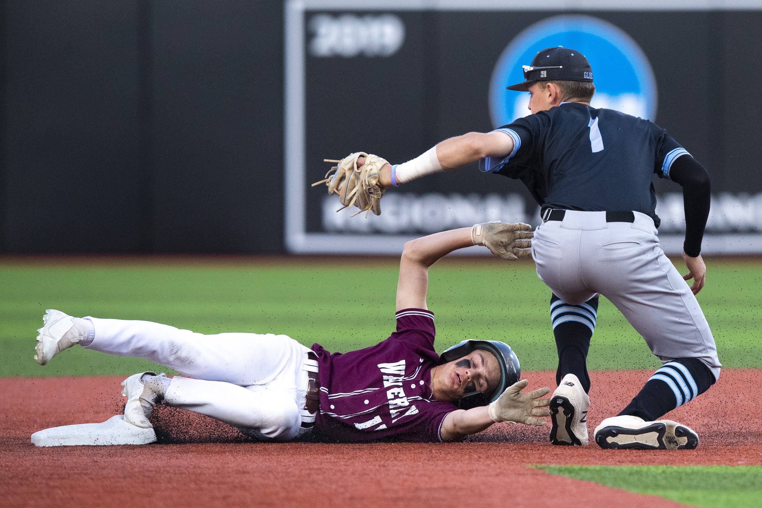  Waverly's  Aden Smith is tagged out while sliding to second base by Elkhonrn North 's Nathan Cunningham in the third inning during the Class B championship at Tal Anderson Field on May 20, 2022, in Omaha, Nebraska. 