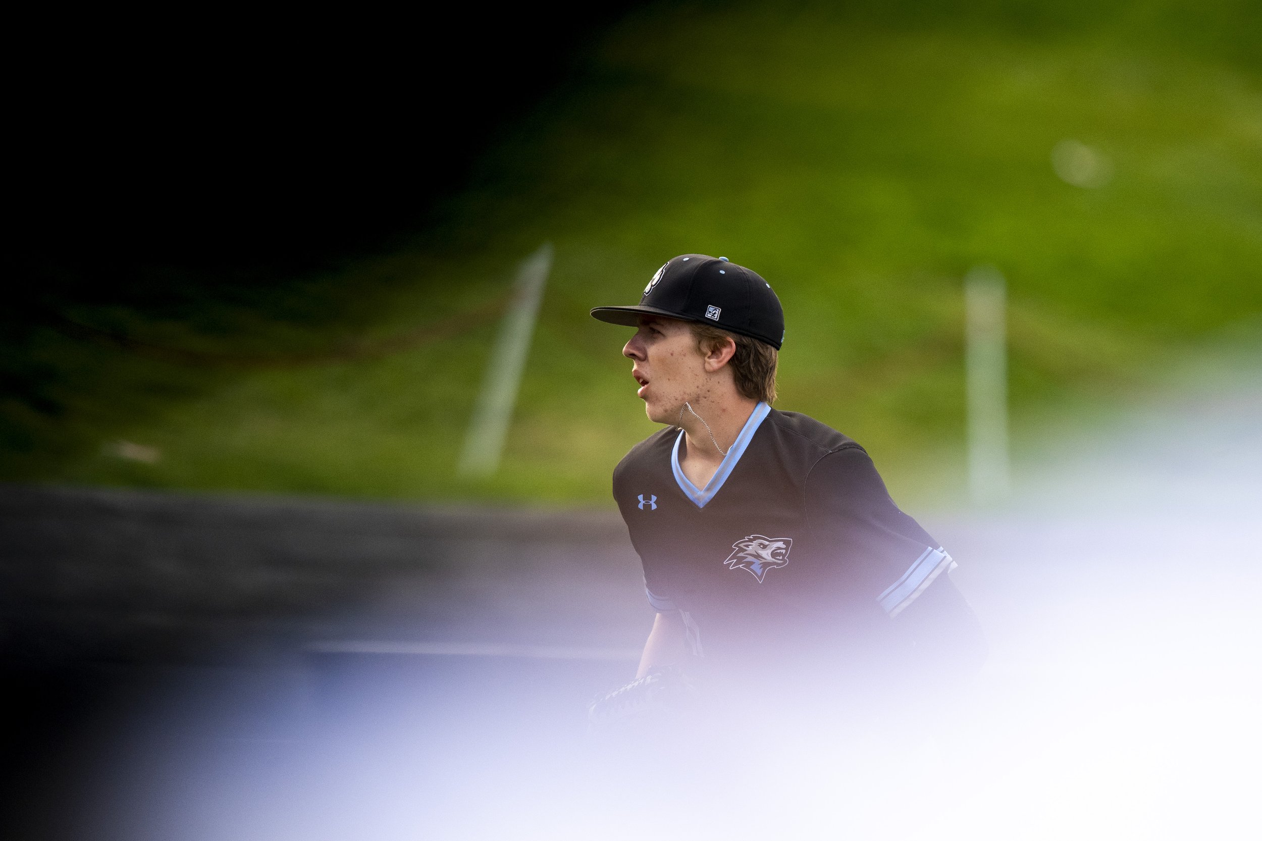  Elkhonrn North 's Colin Nowaczyk is framed between a teammates jersey and the reflection of a railing as he  runs back to the duggout in the second inning during the Class B championship at Tal Anderson Field on May 20, 2022, in Omaha, Nebraska. 