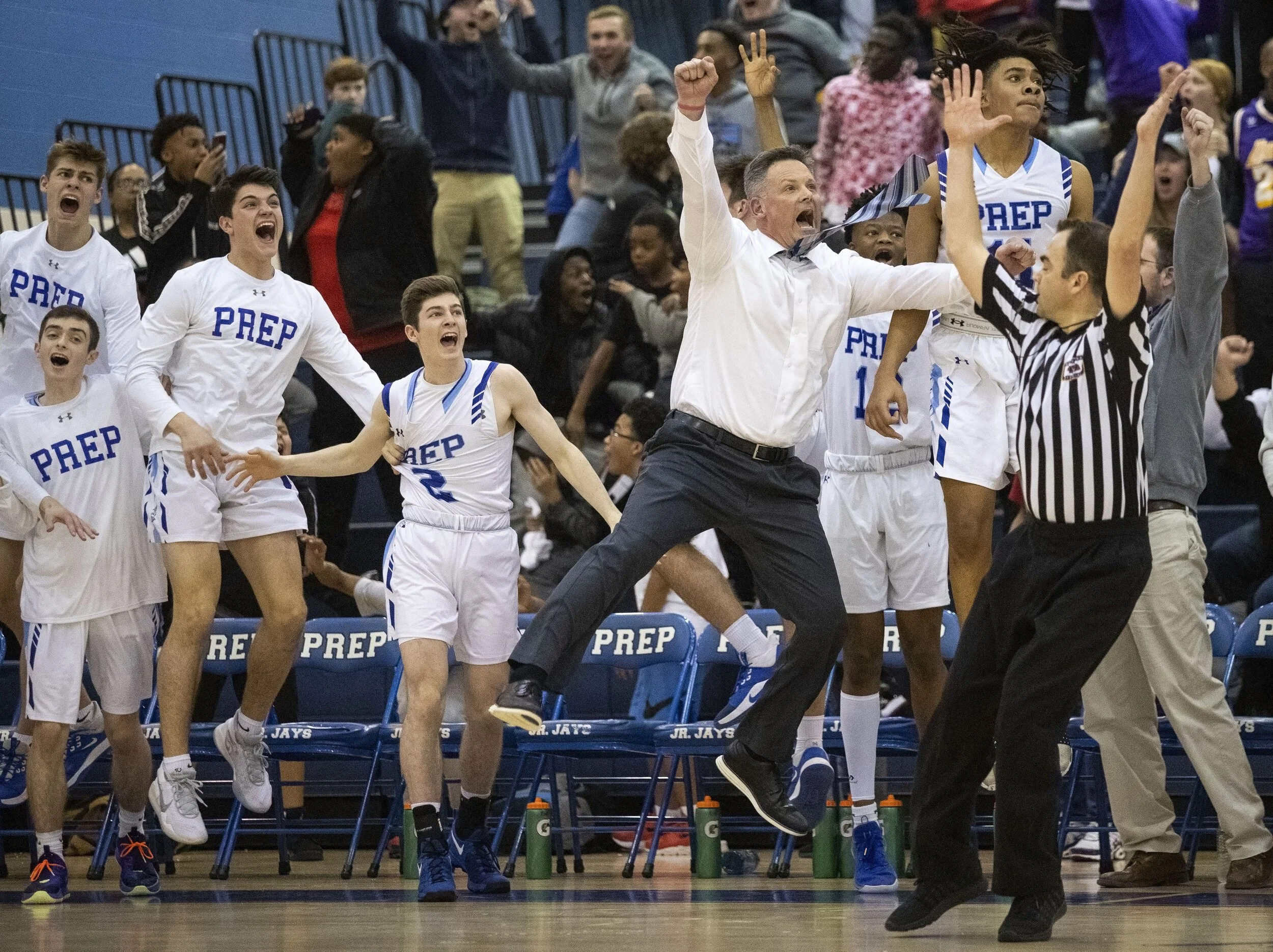  Creighton Prep head coach Josh Luedtke and his team leap off the bench after a buzzer-beater shot by Spencer ‘showtime’ Schomers, not pictured, on Friday, January 31, 2020, at Creighton Preparatory School in Omaha, Nebraska. With 0.7 seconds left on