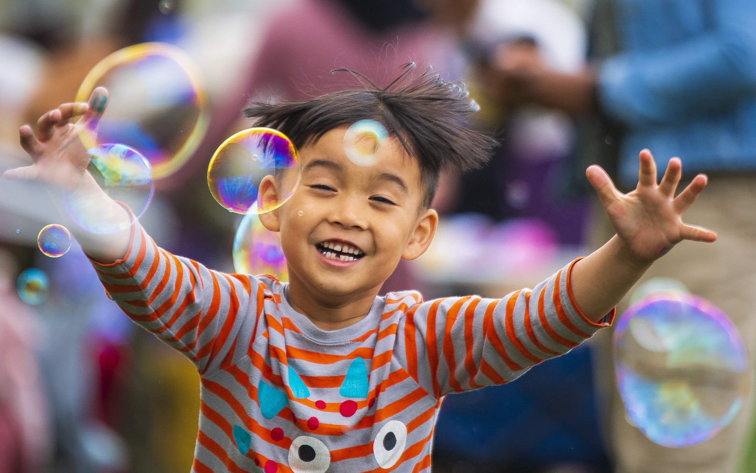  Six year-old Hsa Lay Hser revels in a cascade of bubbles as he tries to pop them all before they fly away during a free event called Bubblepoolza on Tuesday, April 25, 2023, at Whittier Field. 