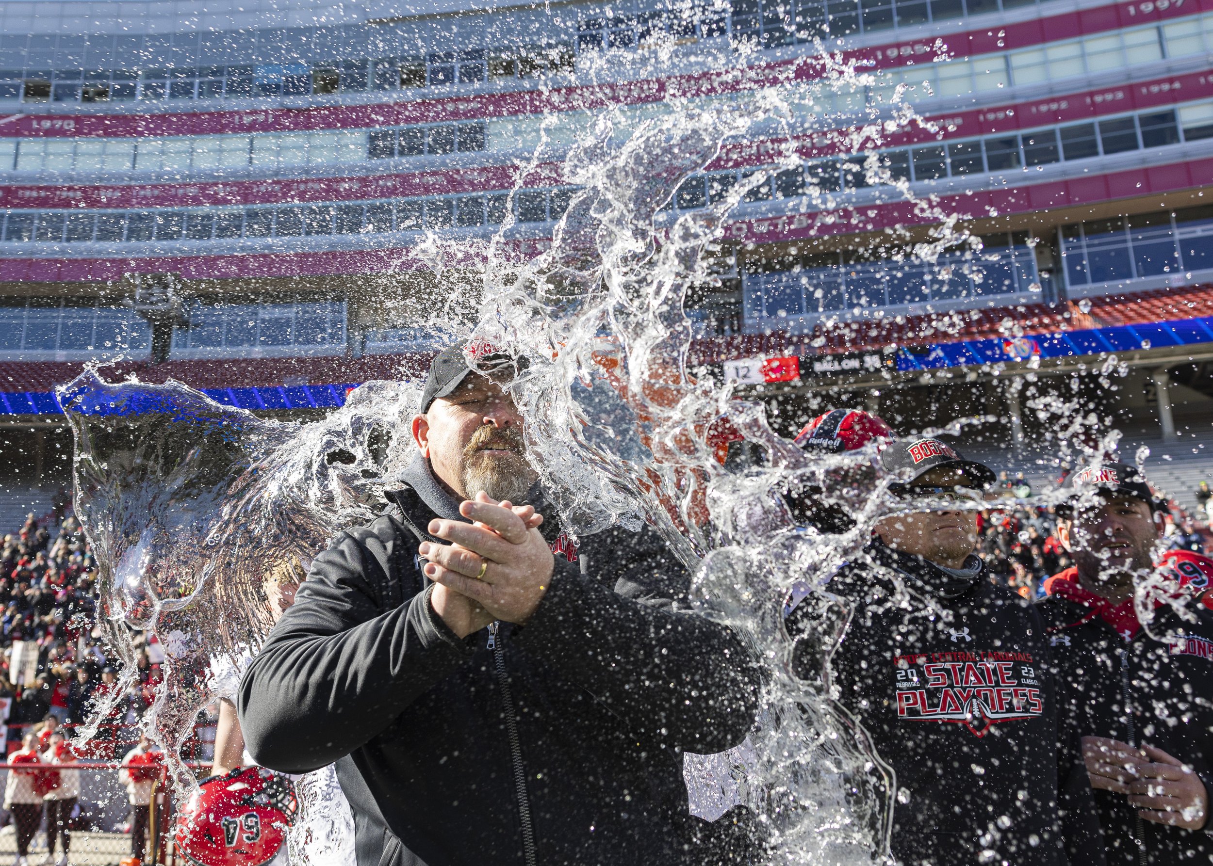  Boone Central head coach Mark Hudson is splashed with water from the water bucket after winning the Class C-1 state championship, at Memorial Stadium, on Tuesday, Nov. 21, 2023. 