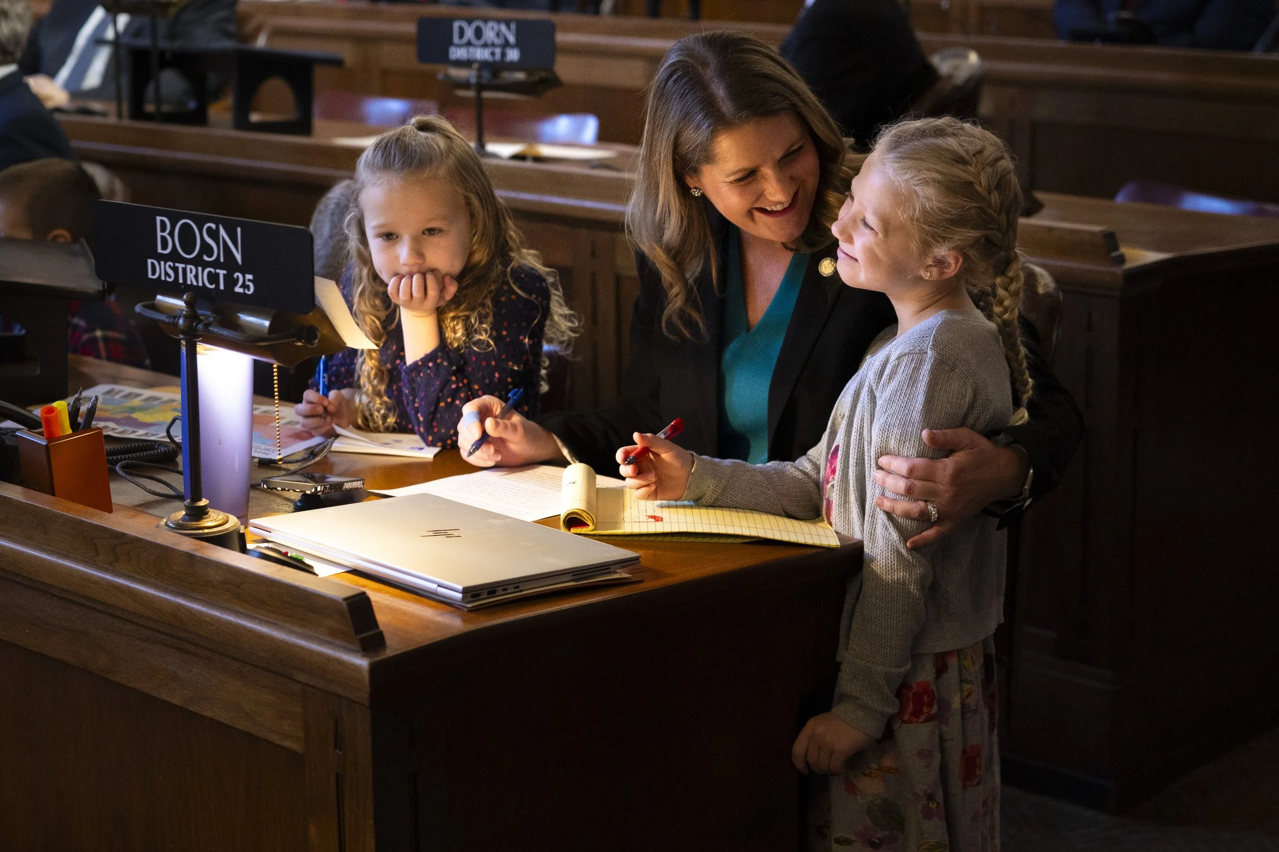  Zoe, 6 (left) and Betsy, 7 (right), spend time on the floor with their mother Sen. Carolyn Bosn of Lincoln (center) during the first day of the legislative session on Wednesday, Jan. 8, 2025, at the Capitol in Lincoln. 