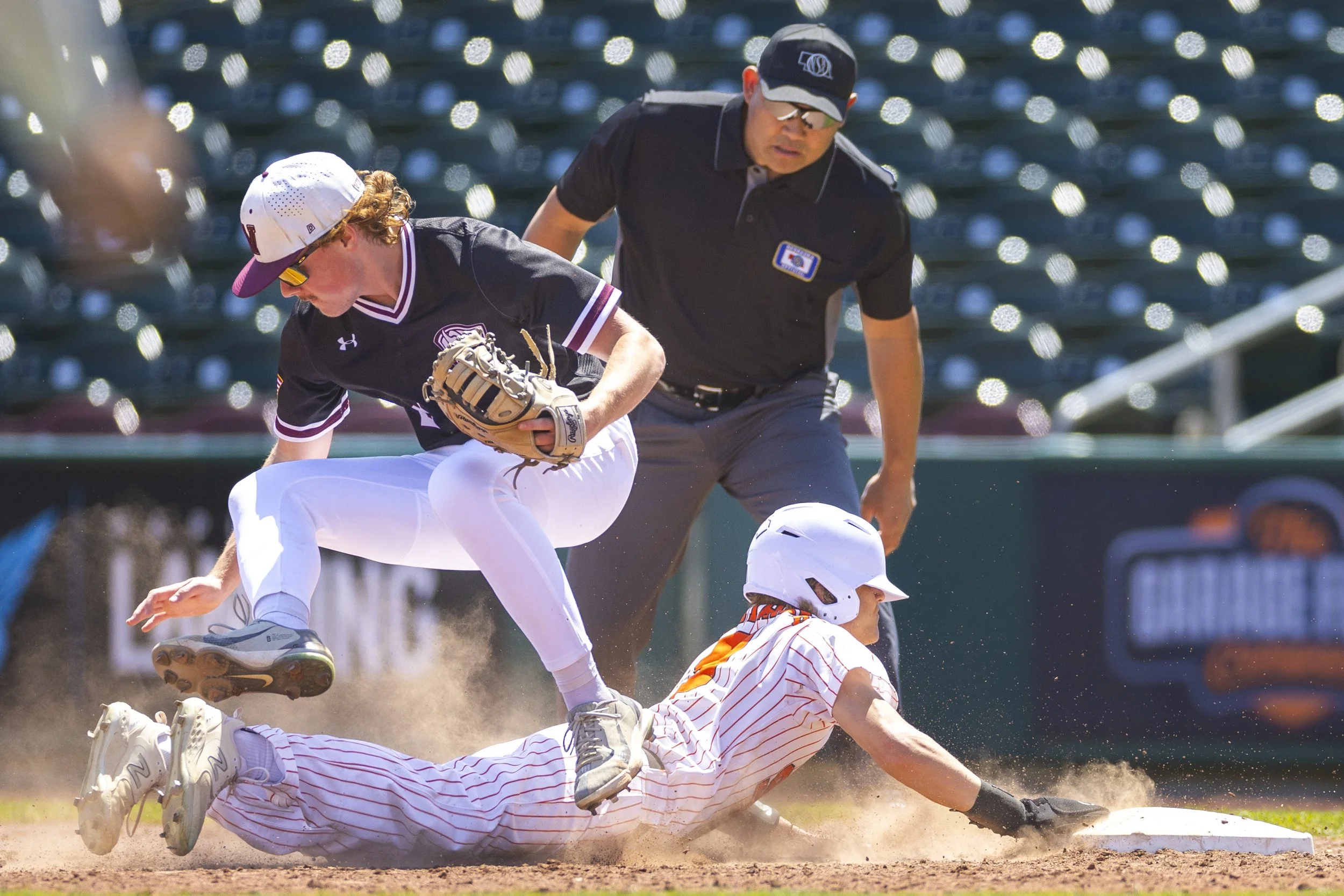 Waverly's Nash Peterson (9) is knockedoff his feet by Beatrice's John Riessen (2) as he slides back to first base during a Class B state baseball tournament game on Saturday, May 11, 2024, at Werner Park in Papillion.