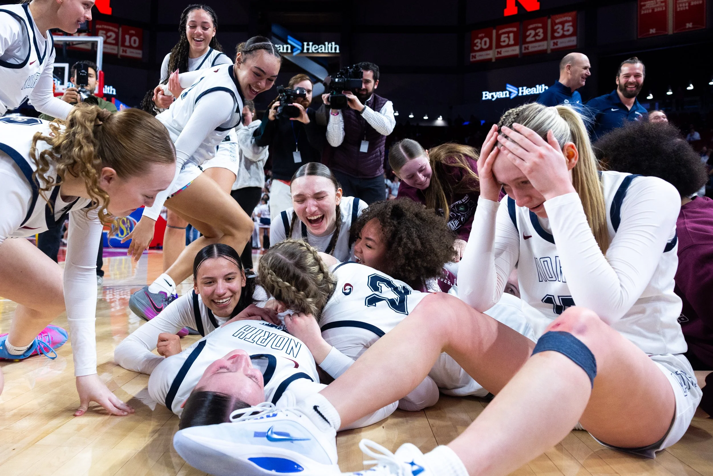  Lincoln North Star players dogpile on the floor after winning the Class A state championship game against Omaha North Saturday at Pinnacle Bank Arena. 