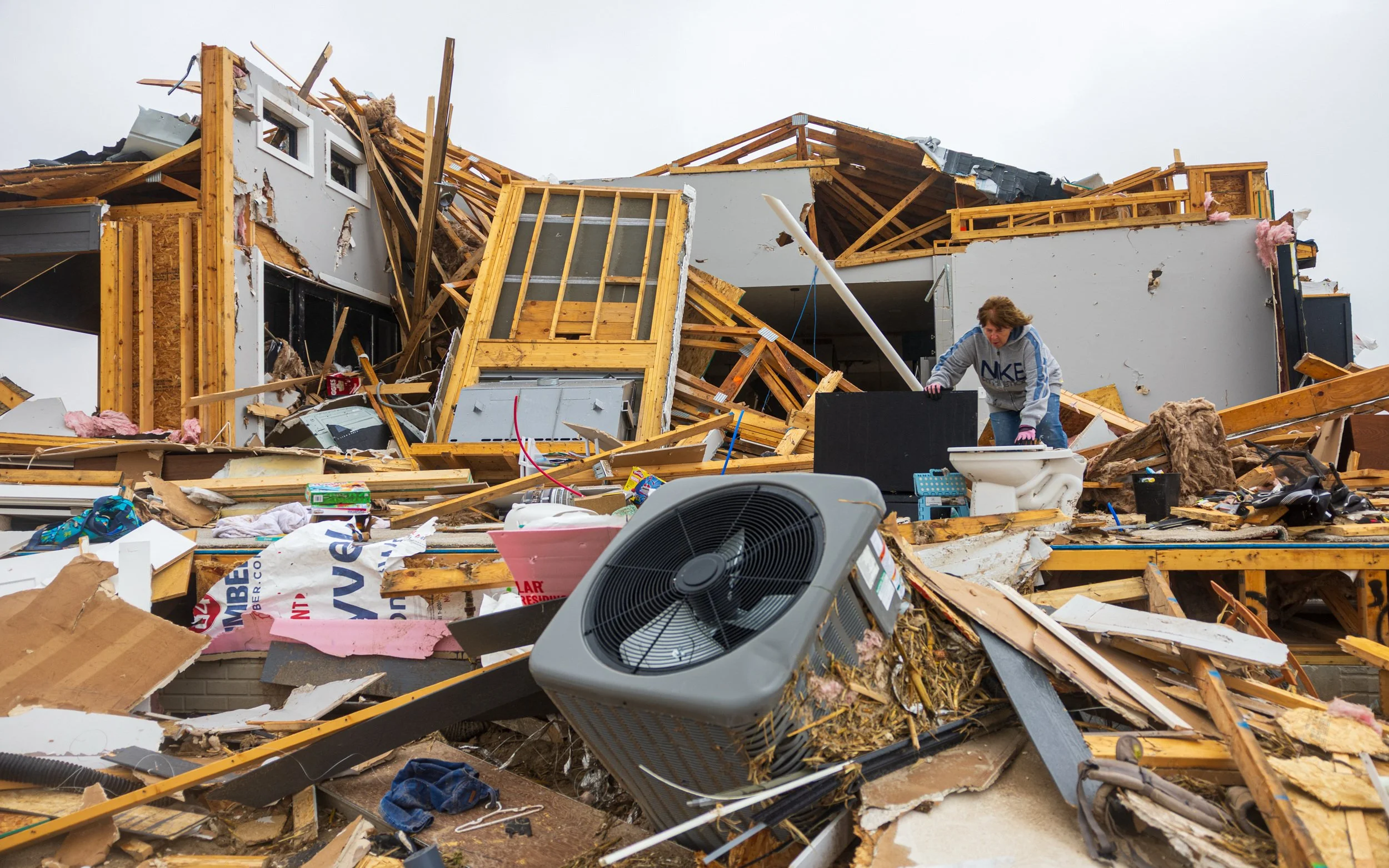 Lora Miller searches the rubble that was the children’s room for valuables and keepsakes after a tornado hit her sons home in the Denton Circle housing development northeast of St. Libory on Monday, May 18, 2026.