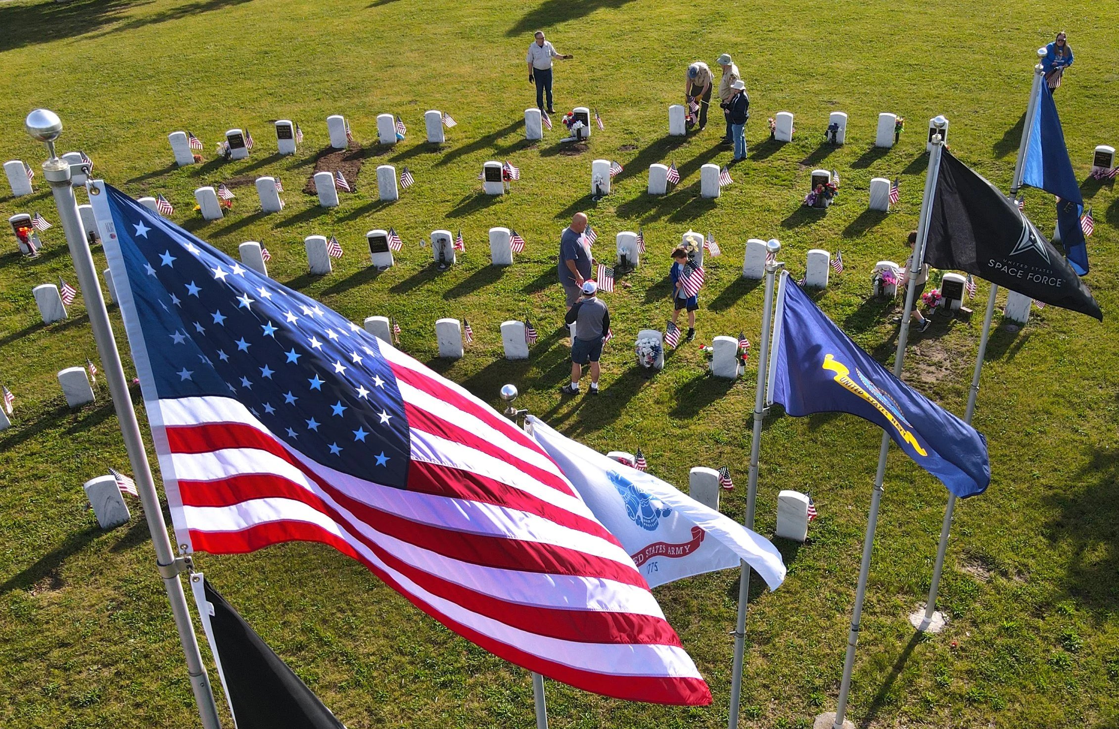 Members and volunteers with Troop 12 Boy Scouts plant flags at the graves of military members on May 23, 2026, at Wyuka Cemetery.  The Troop 12 Boy Scouts have been doing a service project by placing approx. 1,800 flags on the Soldiers’ Circles at Wy