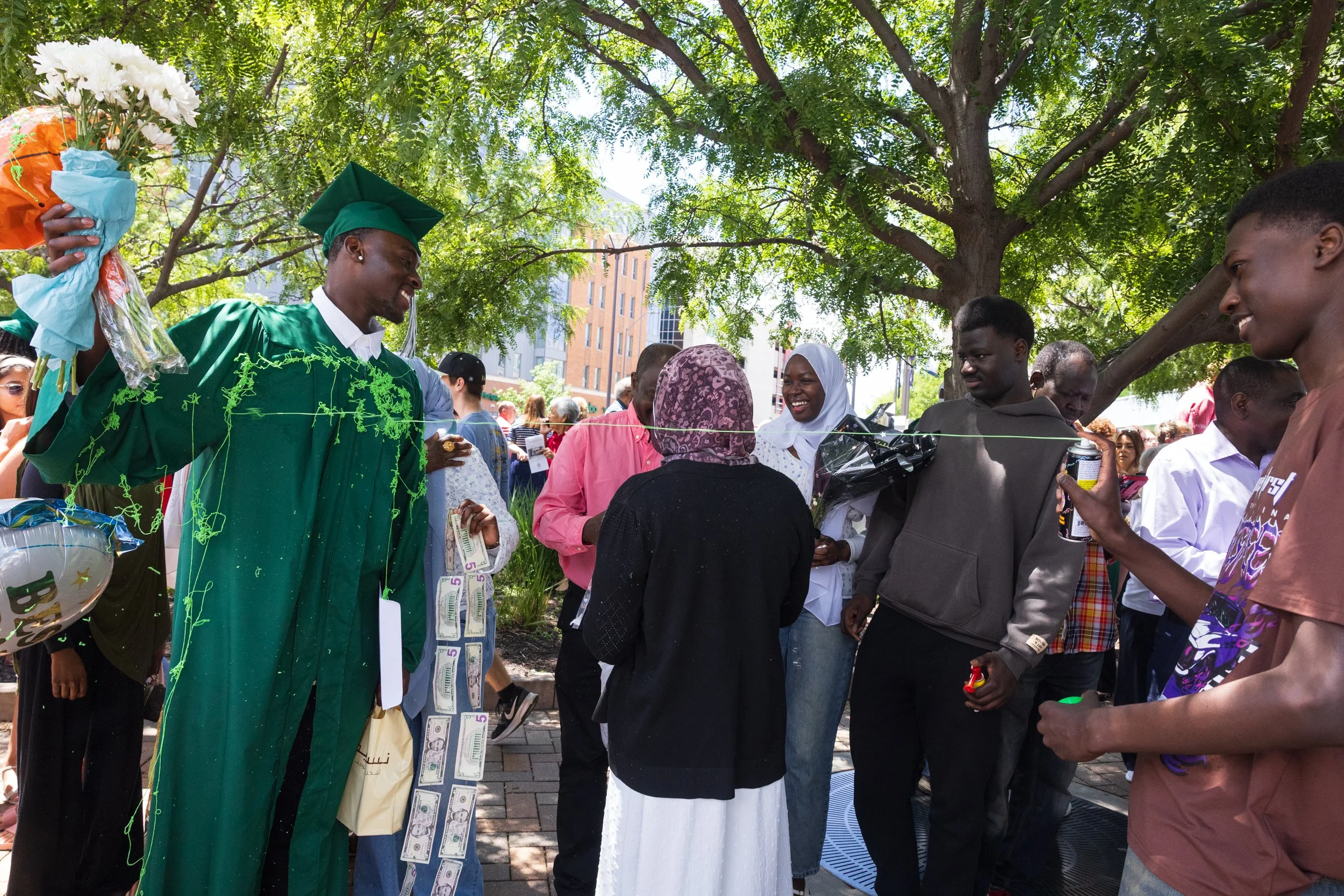 Lincoln Southwest graduate Mustafa Ali Ahmed Guma is sprayed with Silly string by family members after a high school graduation ceremony held on Saturday, May 23, 2026, at Pinnacle Bank Arena. 