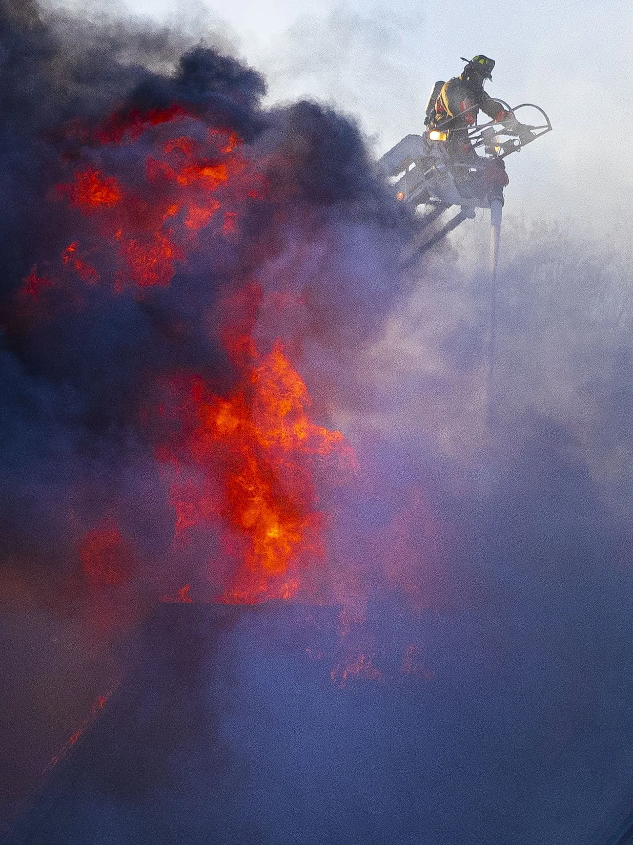 Lincoln firefighter Andrew Brenner sprays water from the top of a ladder truck on to the roof of a former Village Inn at 29th and O streets Wednesday morning.