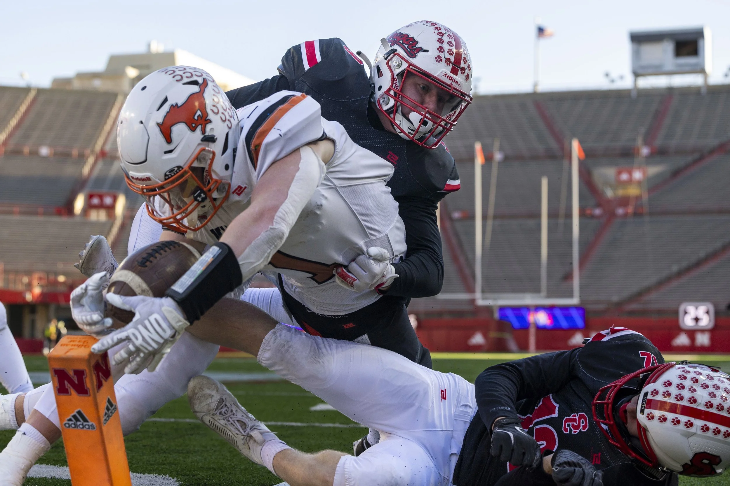 Sandy Creek's Jacob Petr (top) and Sandy Creek's Wes Biltoft (bottom) attempt to stop Stanton's Becker Pohlman as he dives toward the pylon for a two point conversion in the second quarter of the Class D-1 championship game Monday at Memorial Stadium