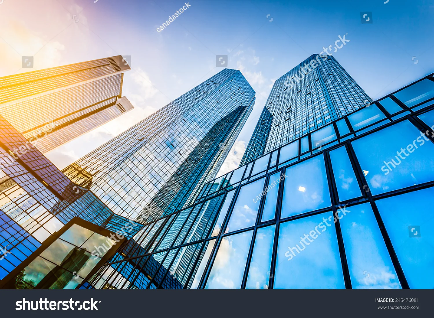 stock-photo-bottom-view-of-modern-skyscrapers-in-business-district-at-sunset-with-lens-flare-filter-effect-245476081.jpg