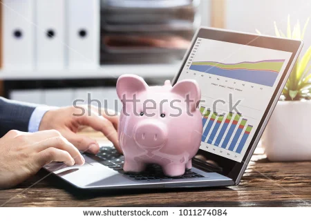 stock-photo-businessperson-analyzing-graph-on-laptop-with-piggy-bank-on-keypad-1011274084.jpg