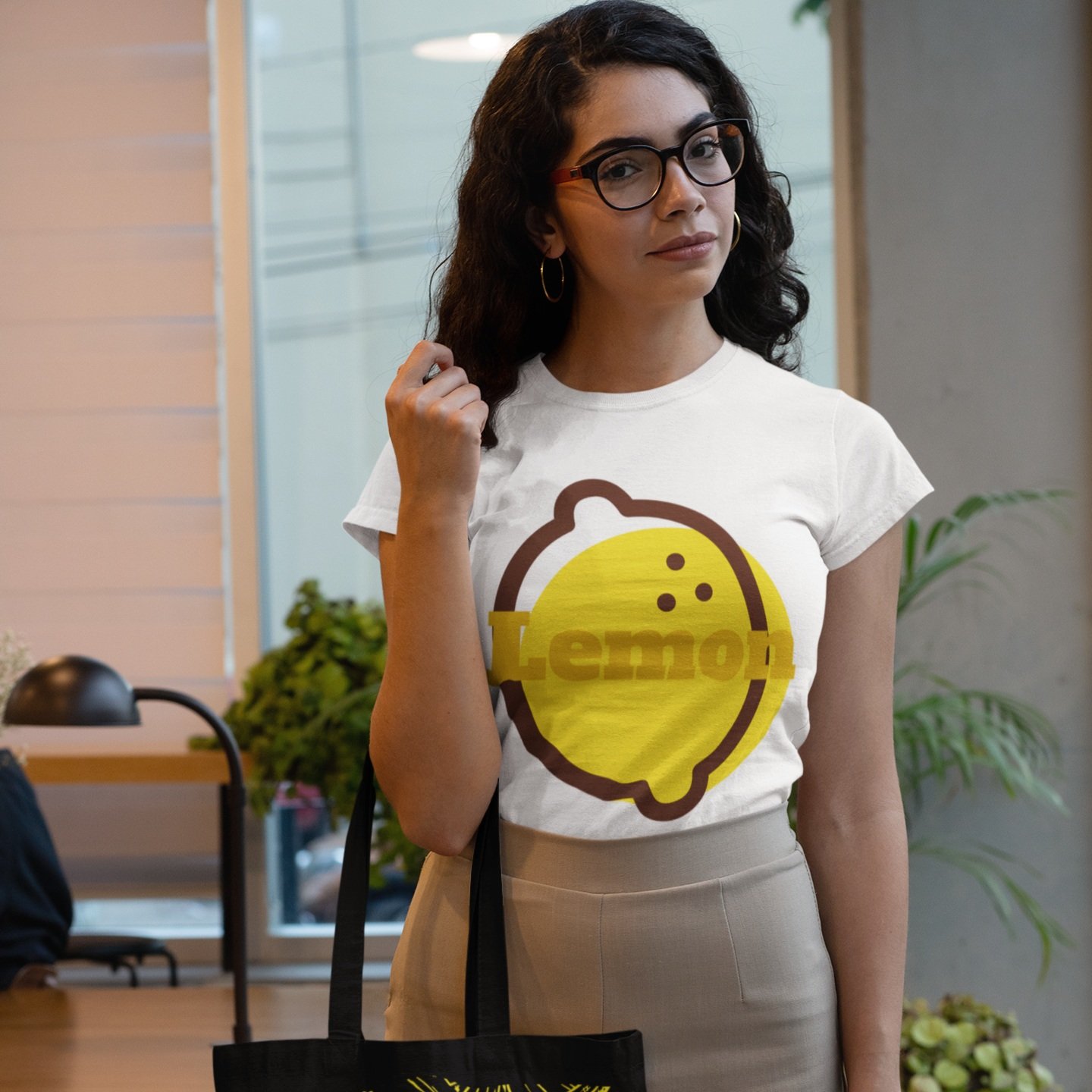 t-shirt-mockup-of-a-woman-holding-a-tote-bag-at-an-office-29413.jpg