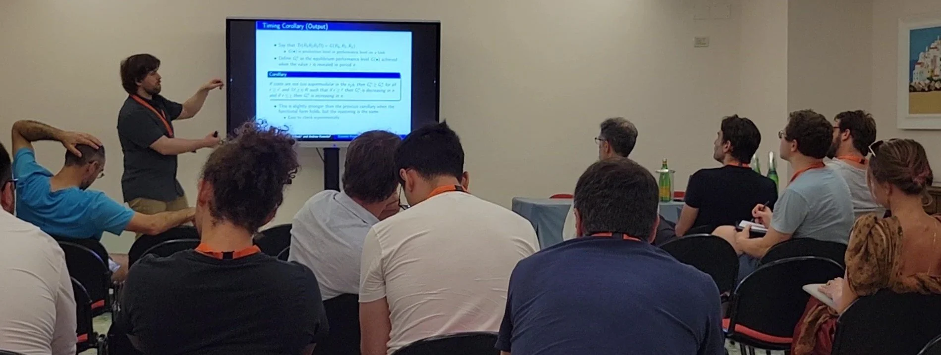 Dr. Neligh stands next to a digital screen at a conference, presenting his research.