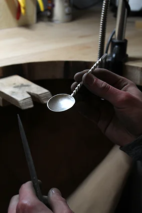 One of our students cleaning up the solder join of their handcrafted silver spoon.