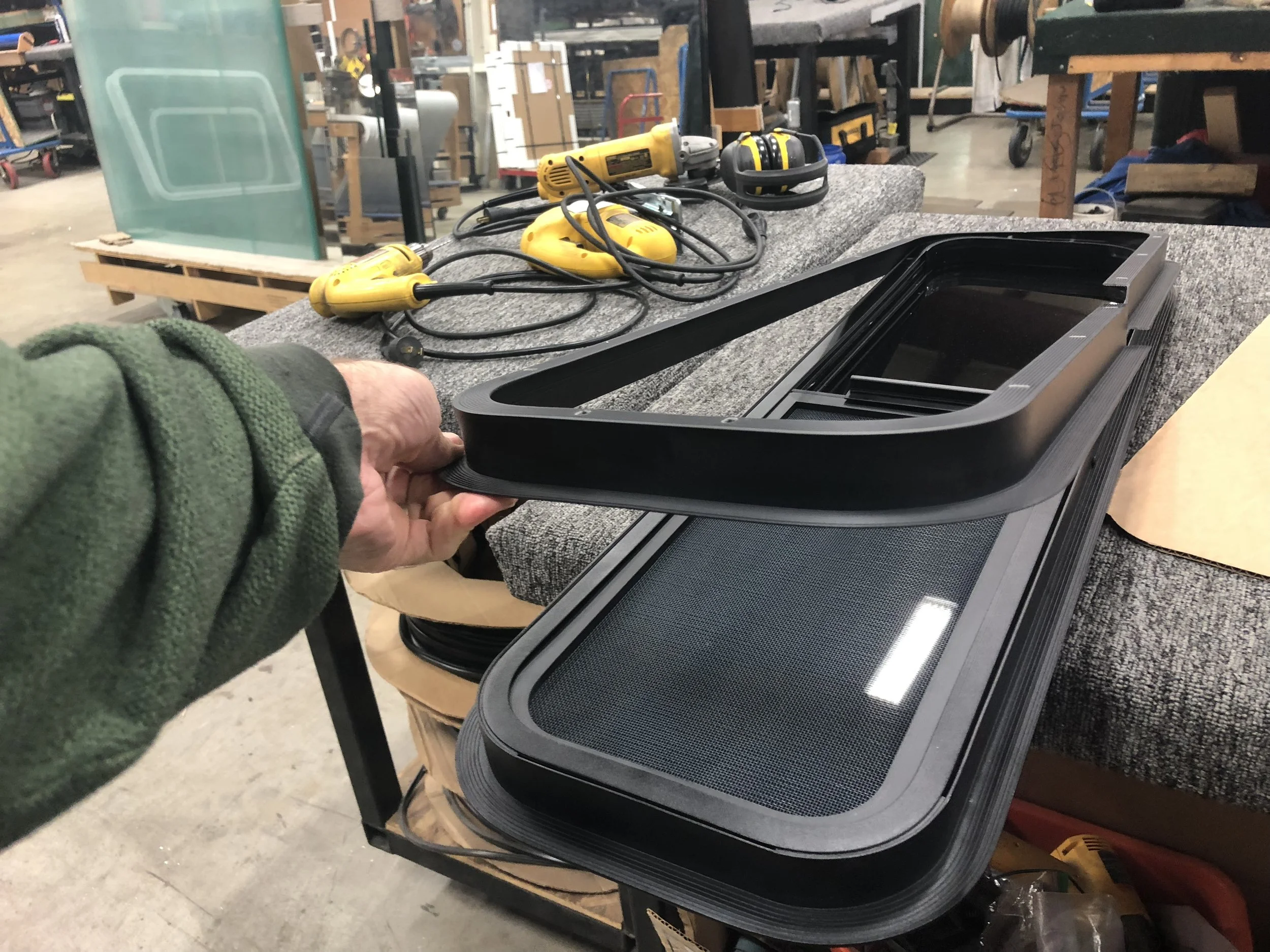The trim ring which clamps the window to the van sheet metal.